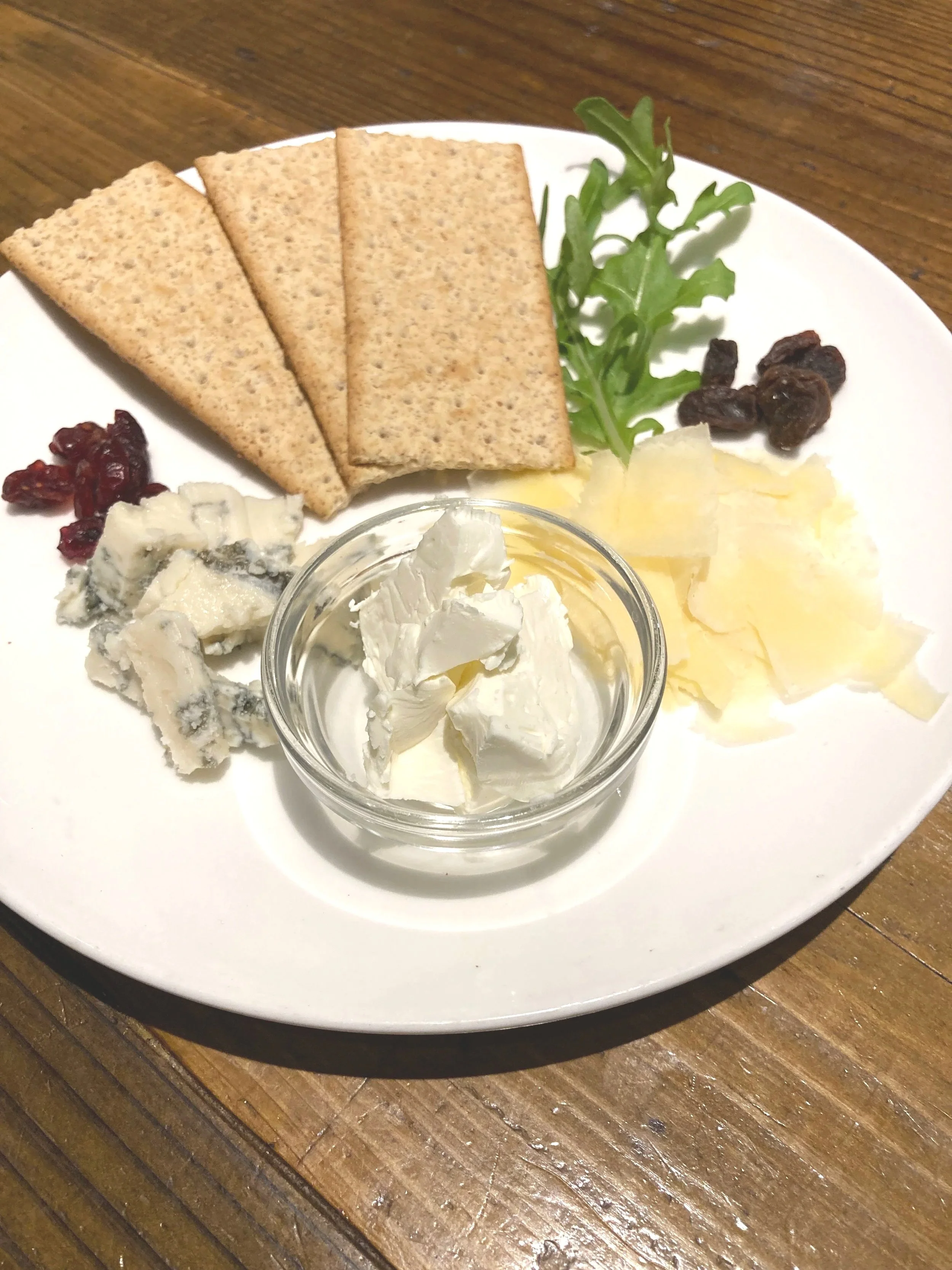 チーズ、クラッカー、ドライフルーツ、レタス、クリームチーズの盛り合わせの写真