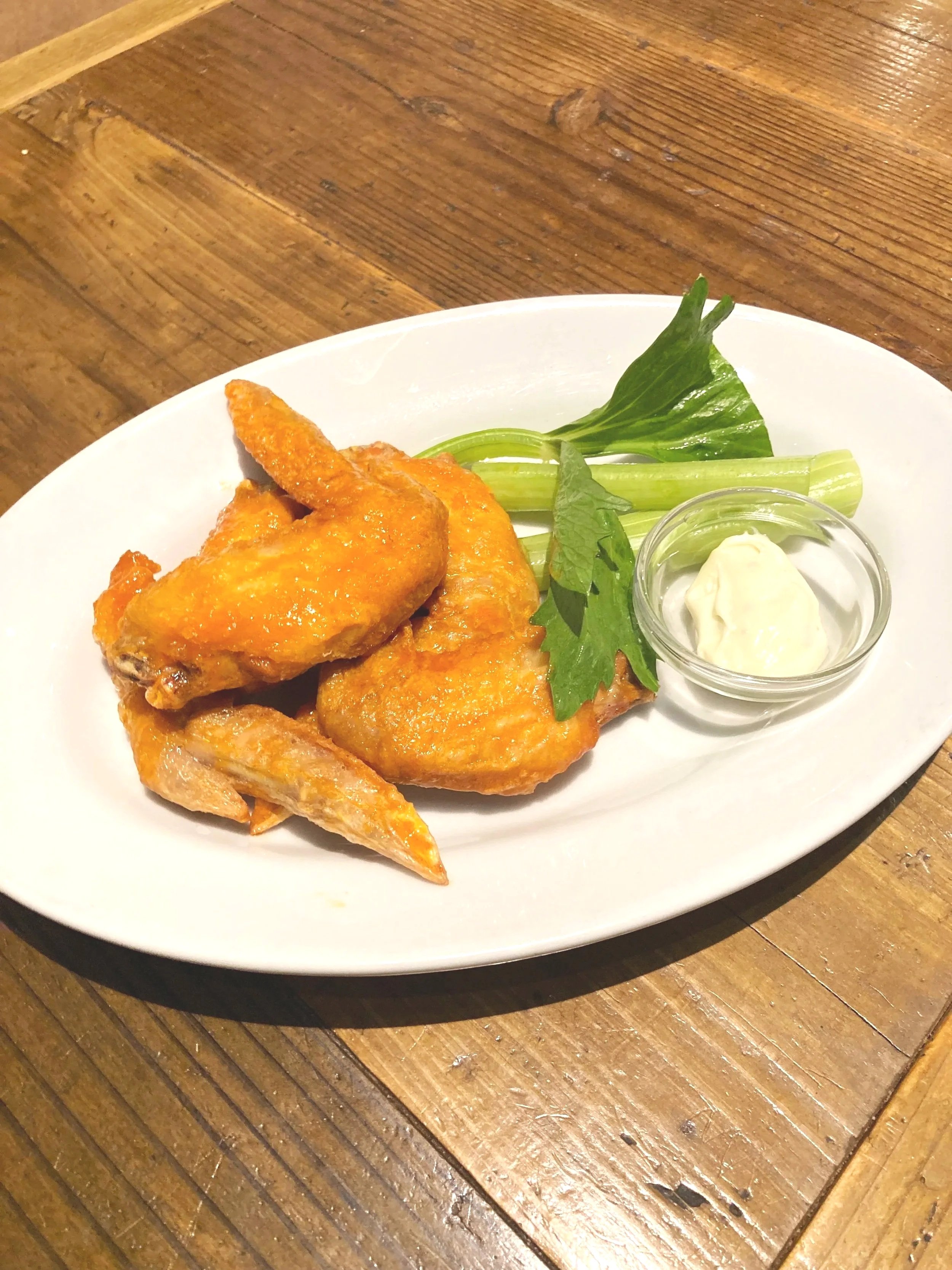 フライドチキンとレタス、セロリ、マヨネーズの小皿が添えられた白い皿の料理