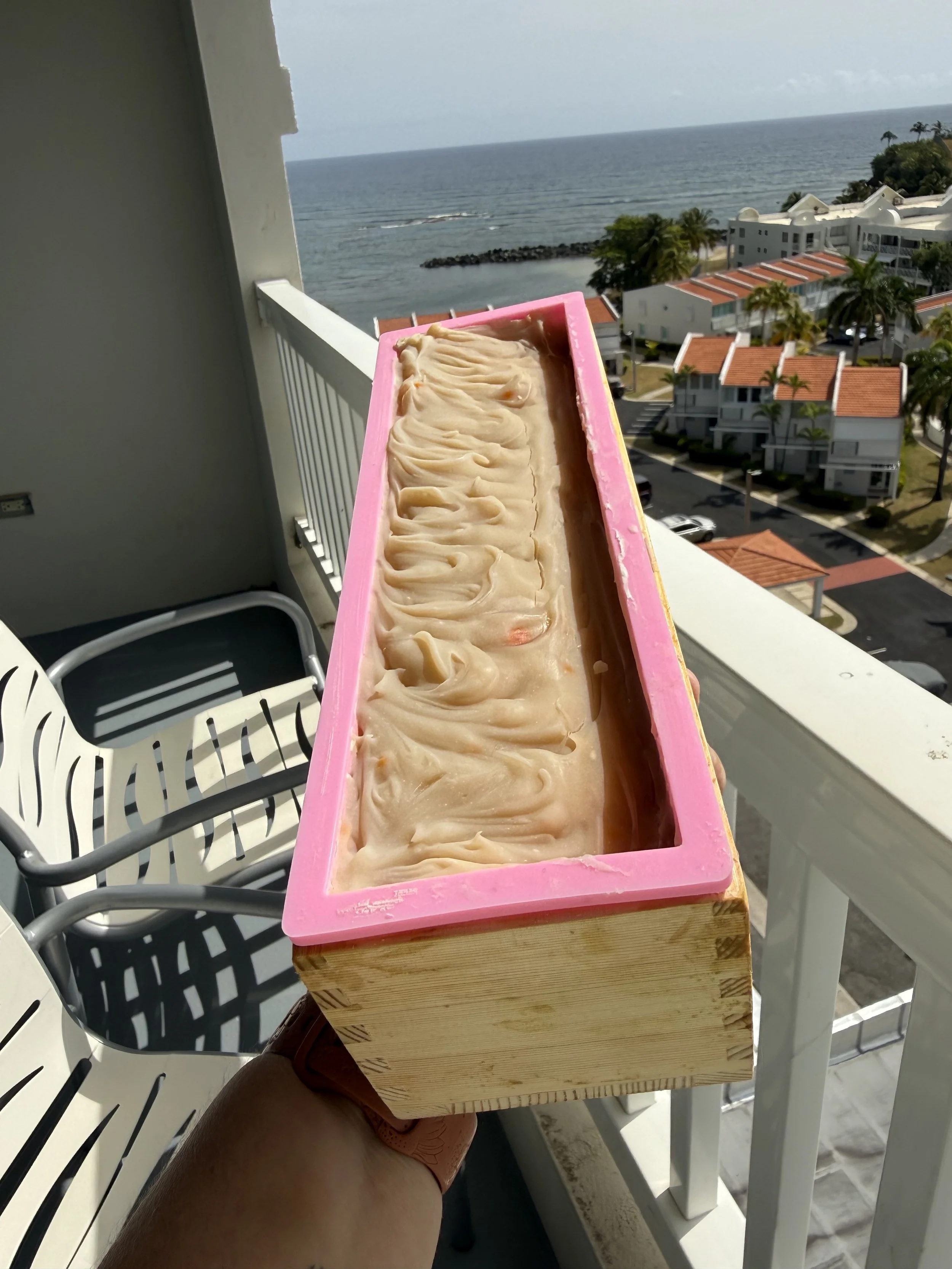 Barra de hielo con una mezcla de sabores en un balcón con vista al mar y edificios con techos rojos.