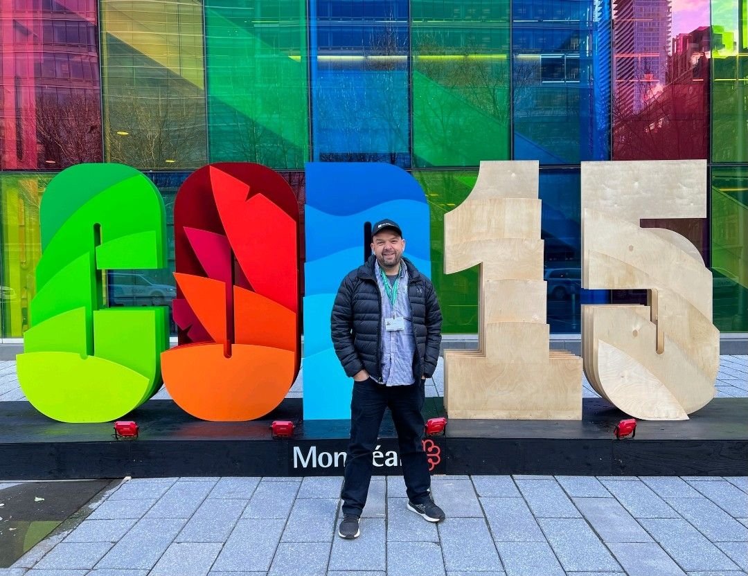 Paul Dettmann stands in front of COP 15 banner at the The 2023 United Nations Biodiversity Conference of the Parties to the UN Convention on Biological Diversity in Montreal