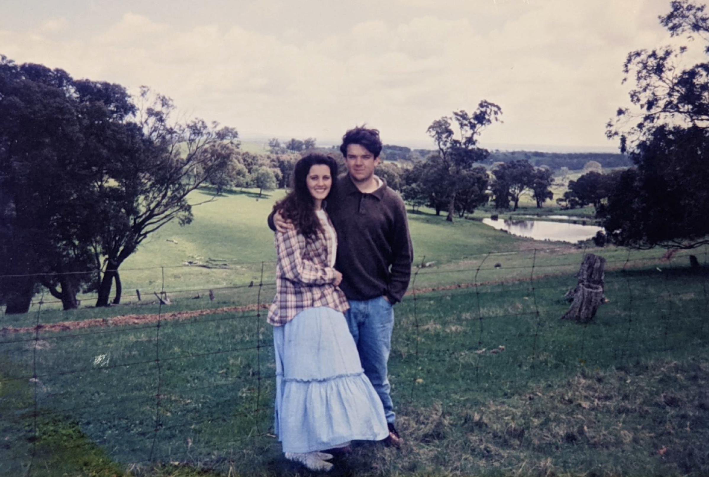 Paul and Rachel stand side by side on farming land