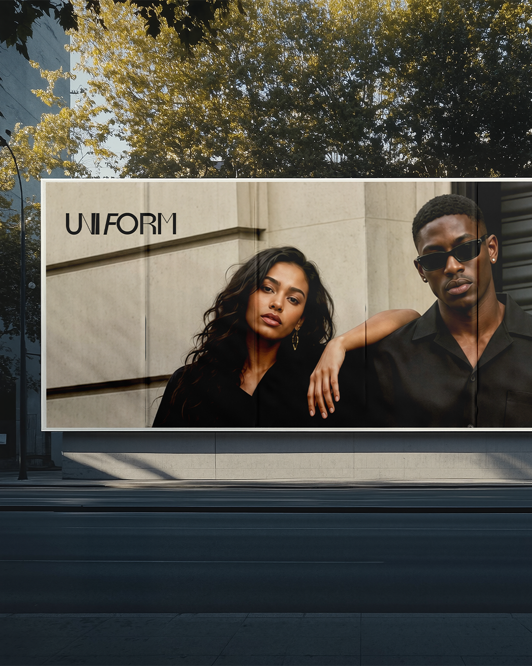 Une publicité extérieure avec deux modèles, un homme et une femme, portant des vêtements noirs, avec le texte 'UNIFORM' en haut à gauche.