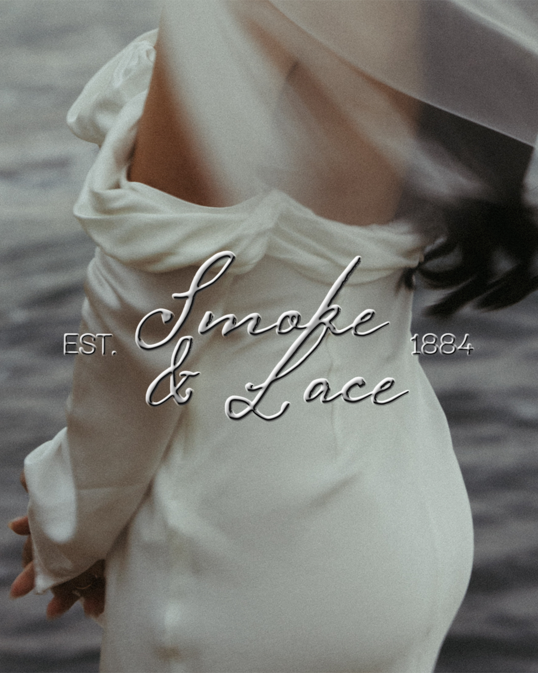 Un profil d'une femme portant une robe blanche avec un nœud au niveau des épaules, tenant un livre, avec l'eau en arrière-plan. Texte sur l'image : "Smoke & Lace, EST. 1884."