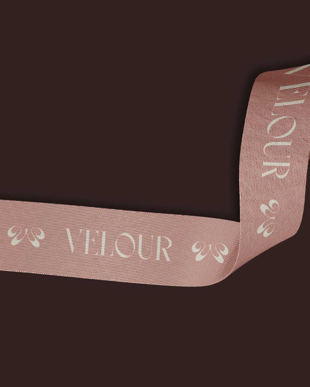 Bandeau en ruban rose avec le logo 'VELOUR' écrit en blanc et des motifs en forme de feux de croix