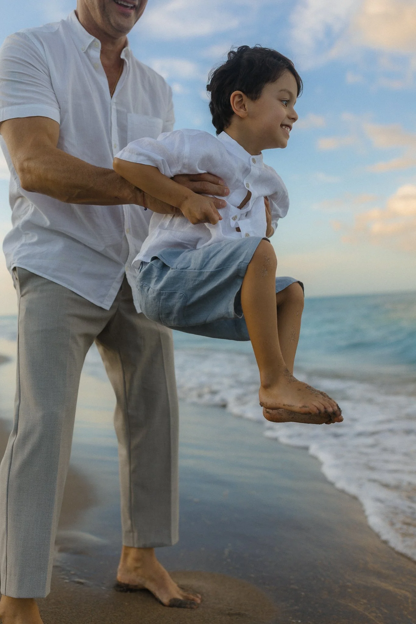 father playing with his young son in the waves
