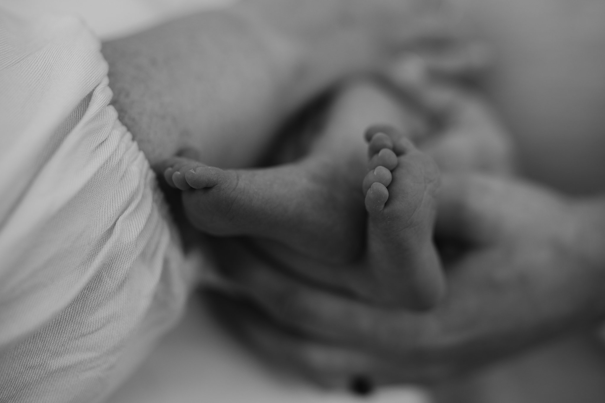 Close-up of a newborn baby holding a finger.