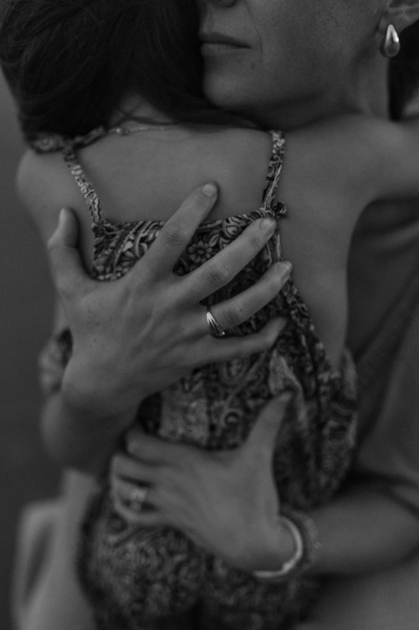 A person hugging a child, with the child's face partially visible. The scene appears emotional and tender.