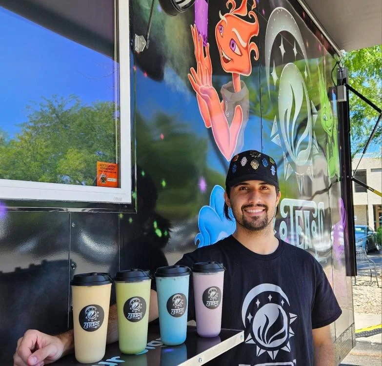 Founder of ZOTEAAC, in front of trailer with a selection of Boba Tea Drinks.