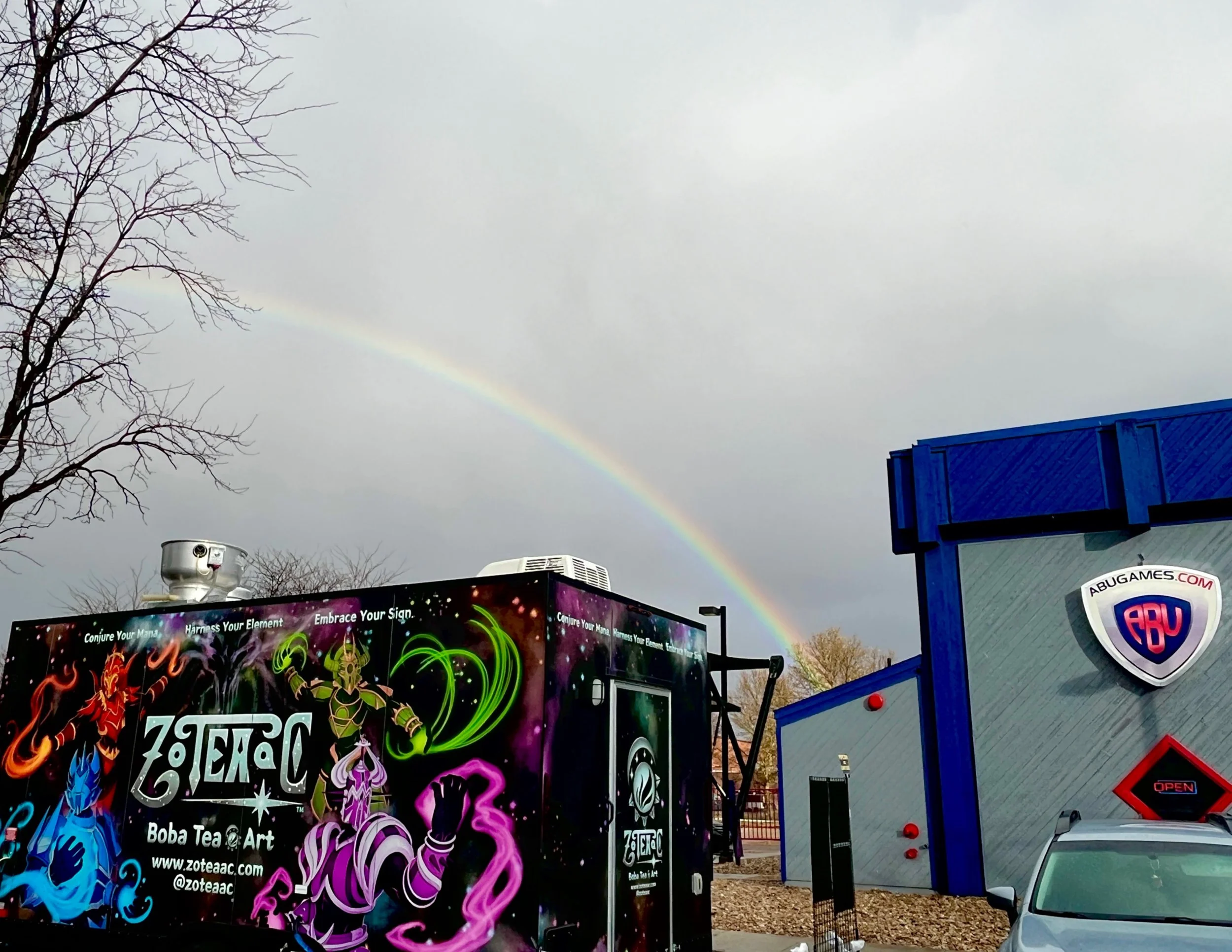 ZOTEAAC's Trailer in front of ABU Games with a rainbow in the background.