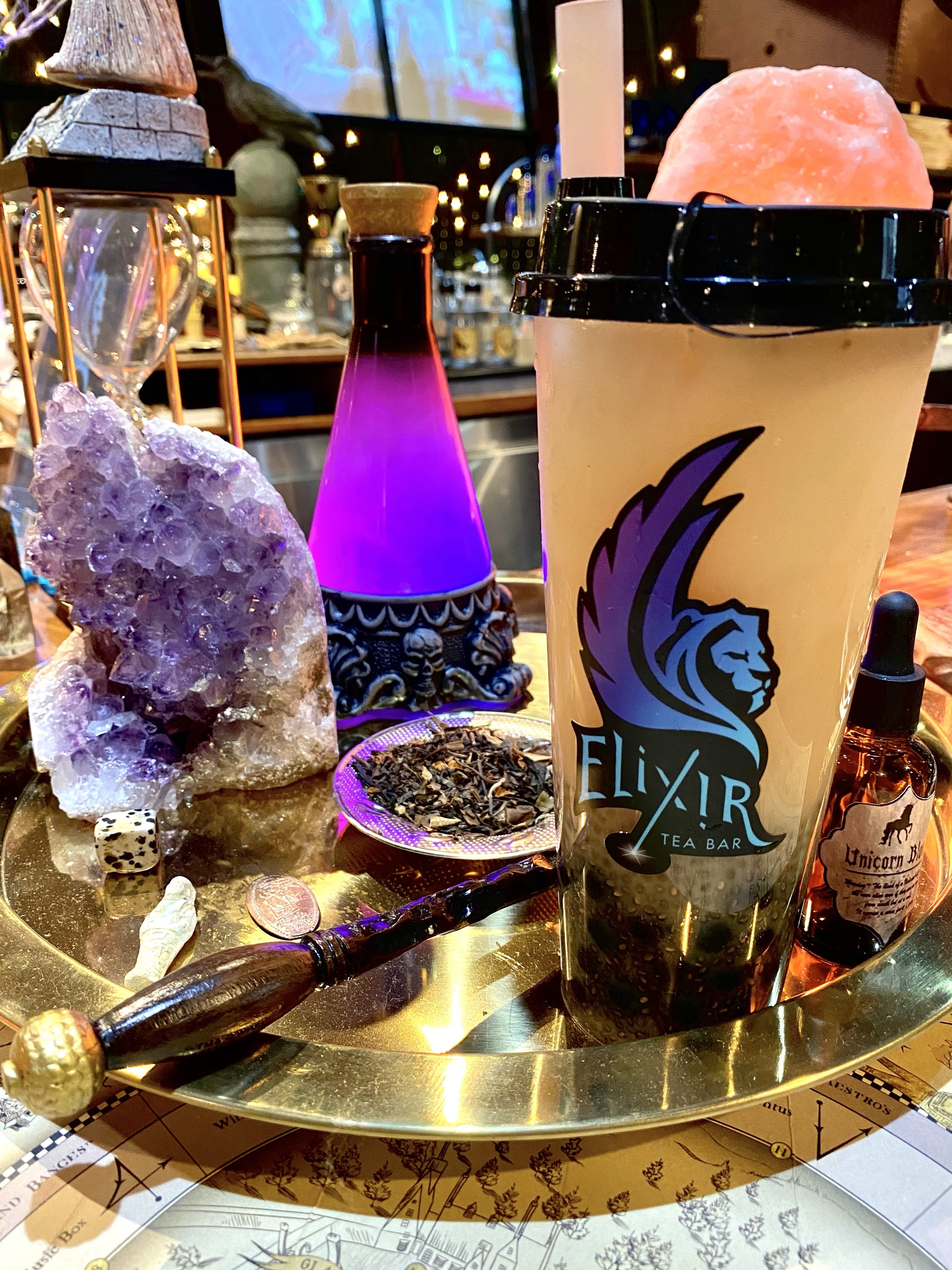 Elixir's logo on Boba Tea to-go cup in decor display.