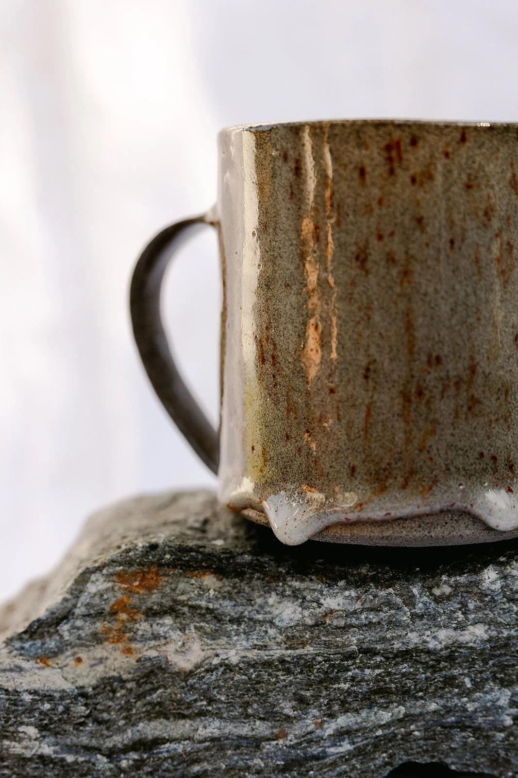 Detail of dripping glaze on a grey stoneware hand made mug
