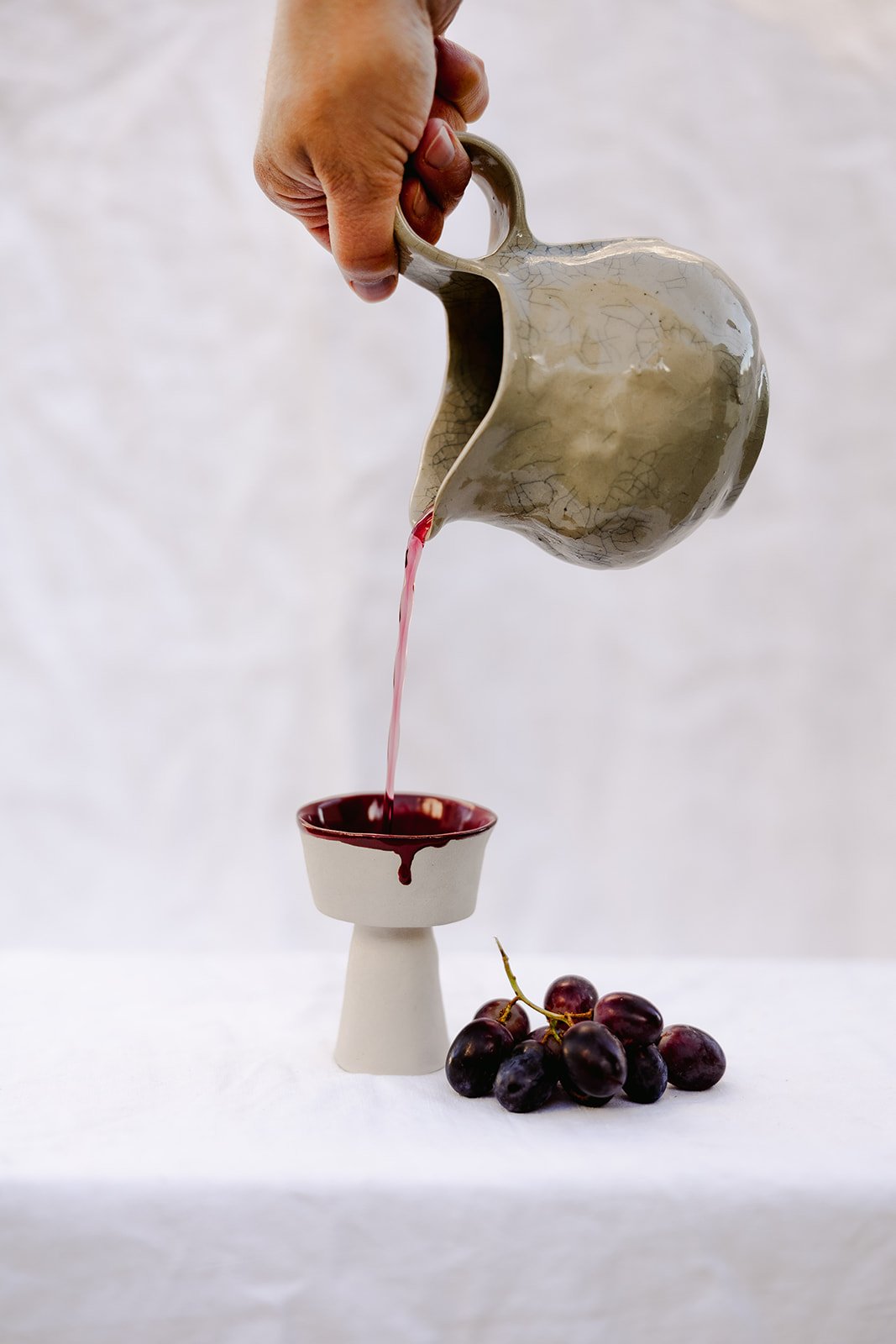 Pouring wine from the hand build wine jug into the communion cup