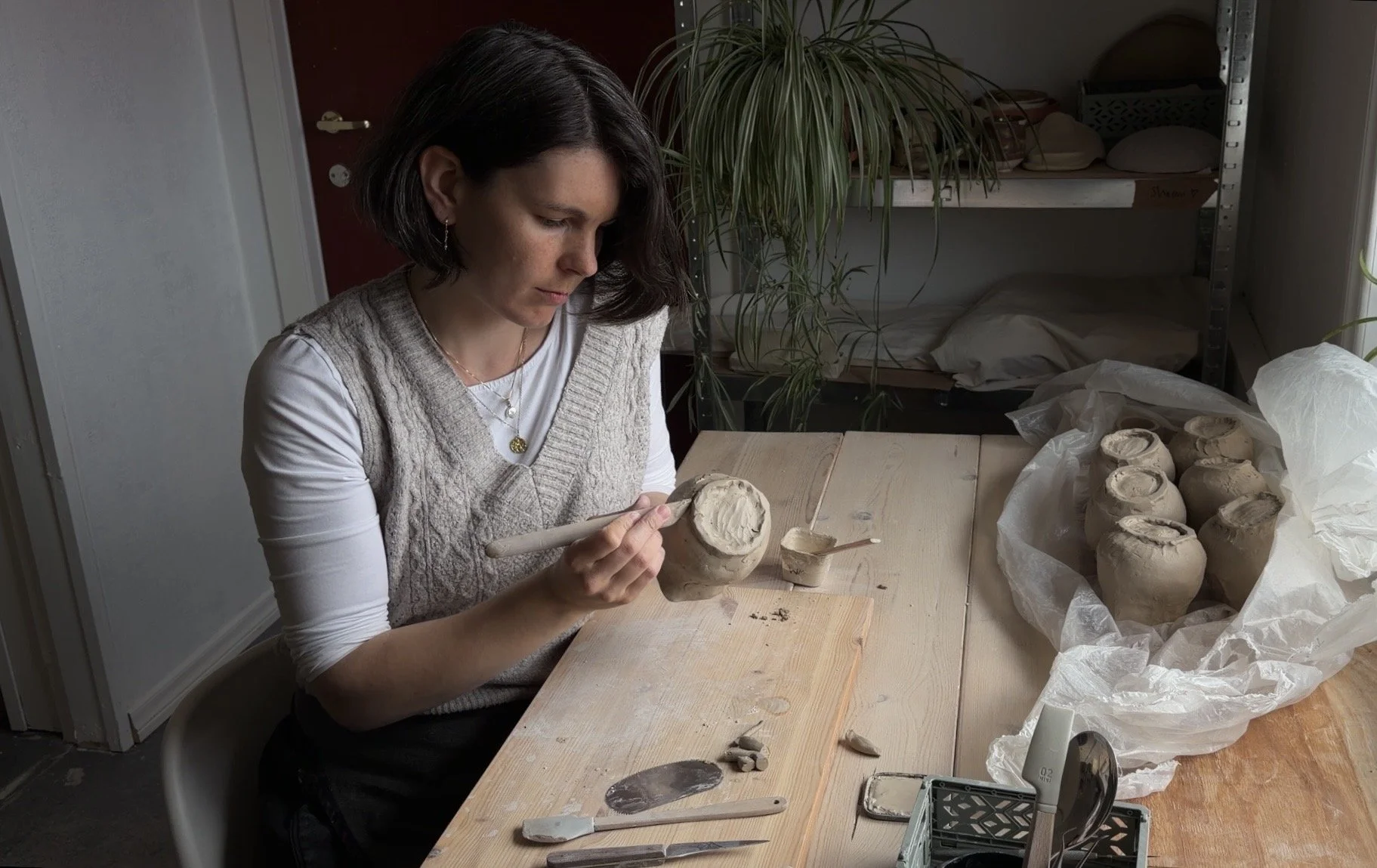 Ceramic artist at work, hand shaping a wine jug