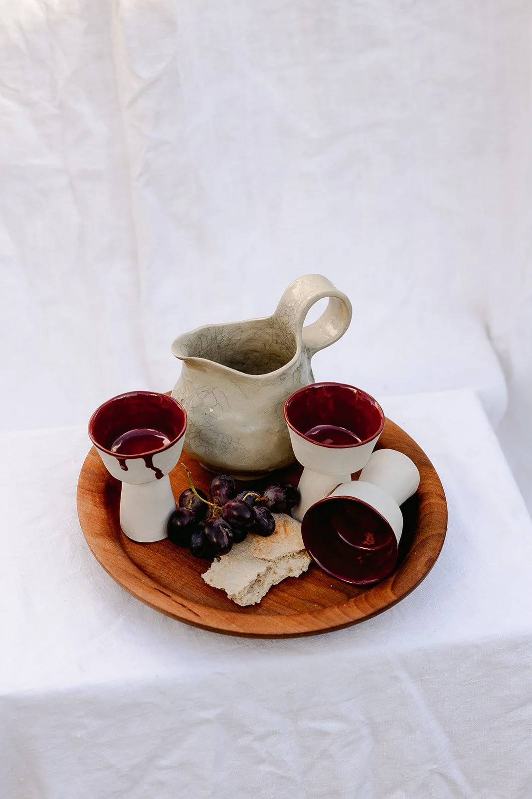 The breaking bread set with a hand build wine jug, two cups and a wooden bowl