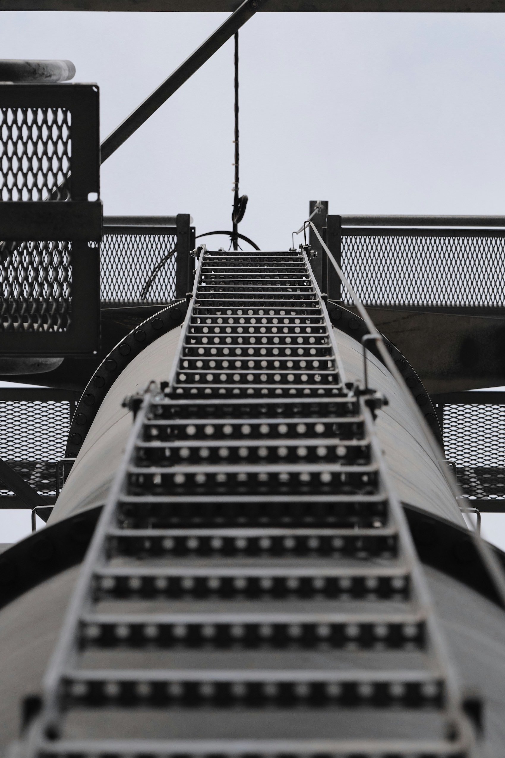 Low-angle view of a metal staircase in an industrial setting.
