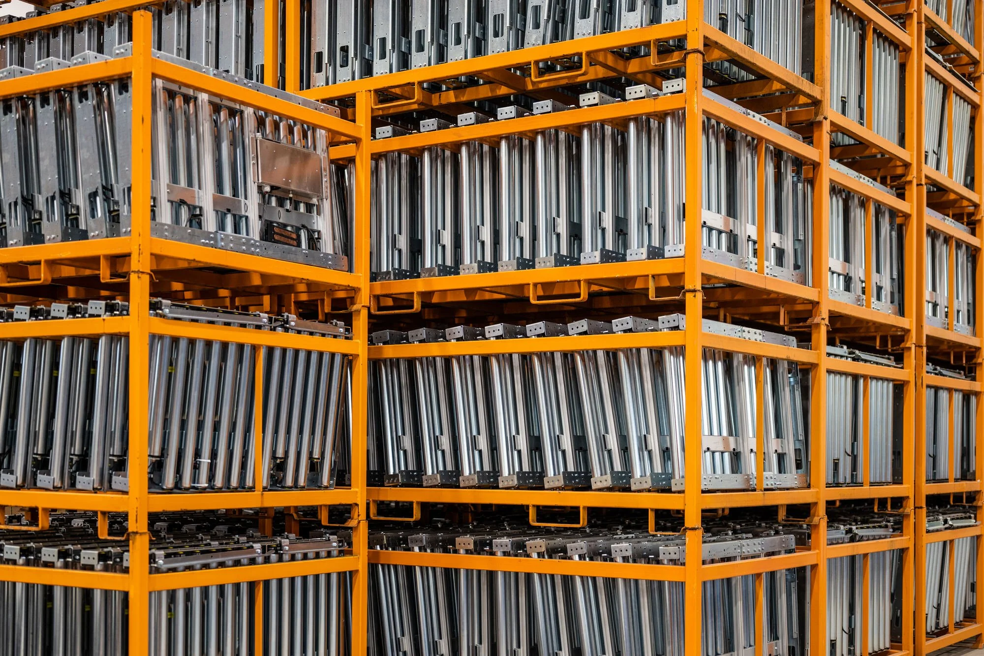 Industrial storage racks filled with metal components in a warehouse.