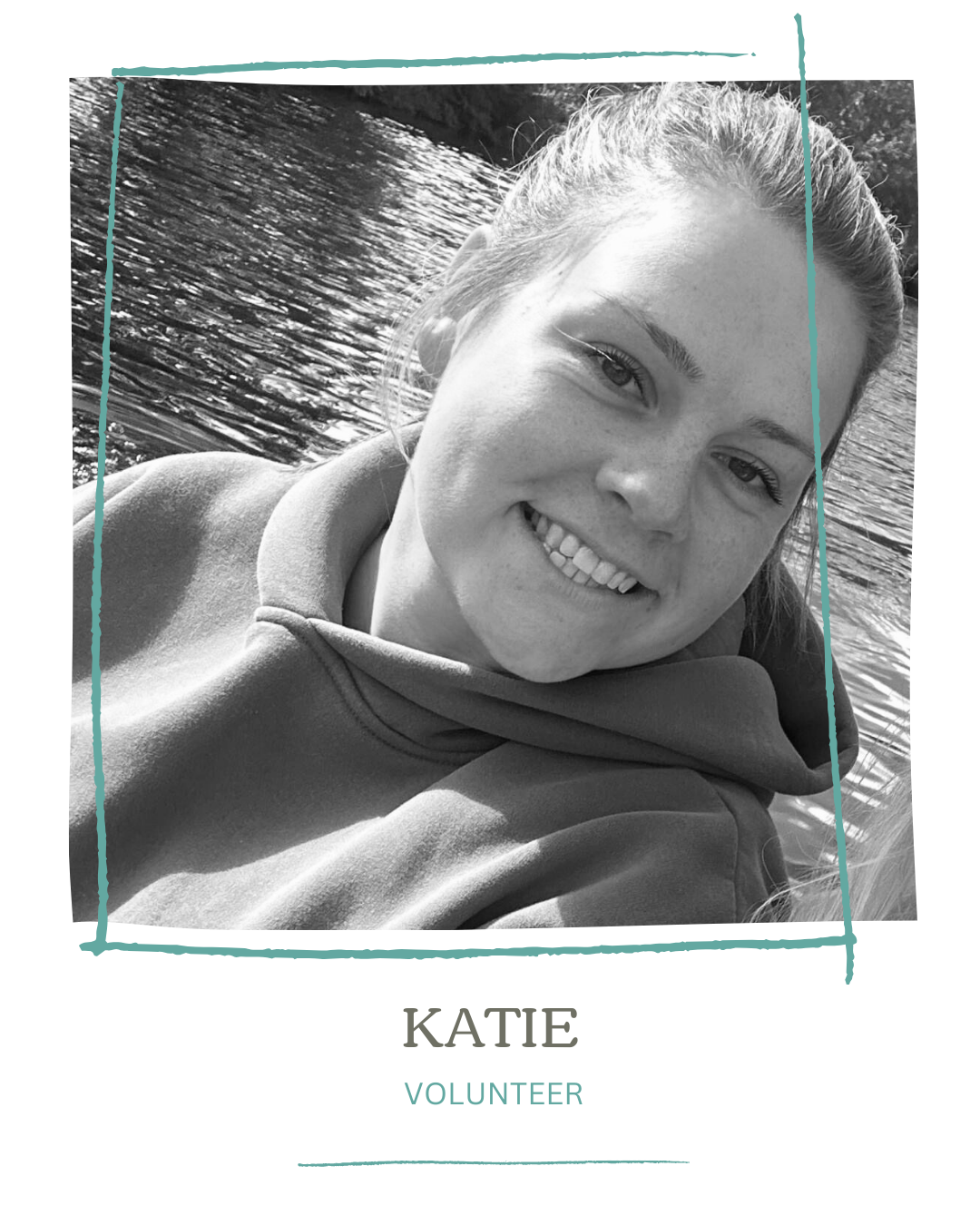 Black and white photo of a smiling young woman with light hair, wearing a hoodie, near a body of water, with a decorative frame and text indicating her name as Katie and her role as Volunteer.