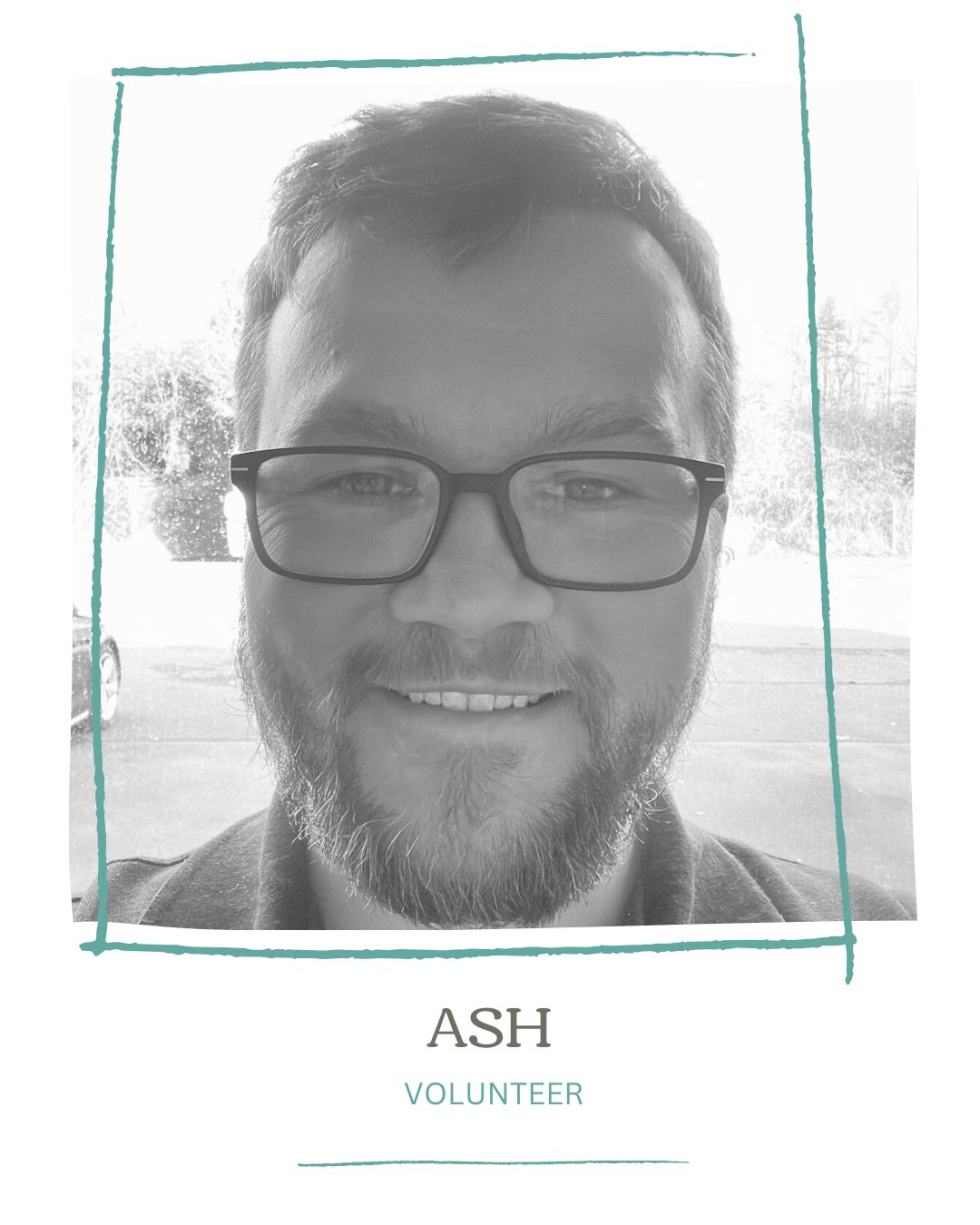Black and white photo of a man with glasses, a beard, and smiling, labeled as Ash, volunteer.