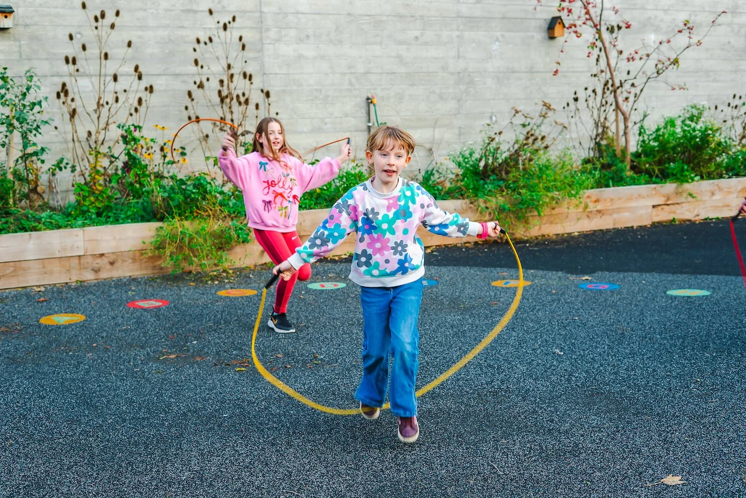 Two young children skipping in the playground.jpg