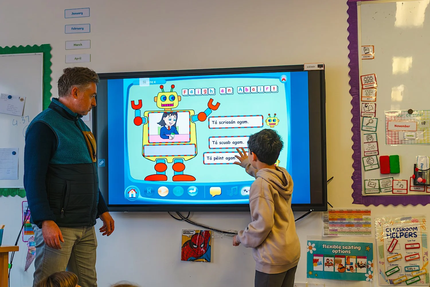 Teacher and child at the interactive whiteboard, learning Irish.jpg