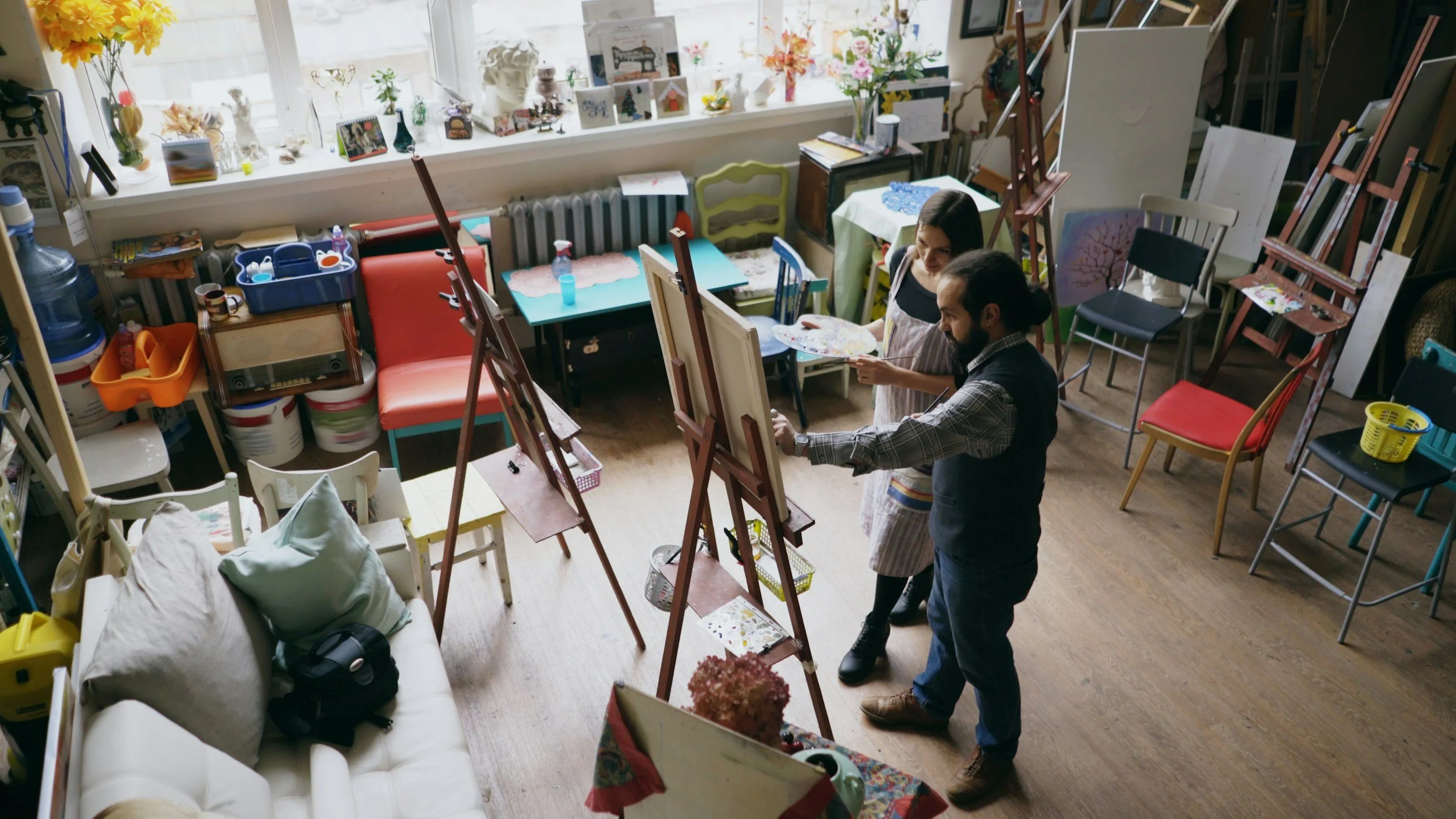 two people standing in front of an easle