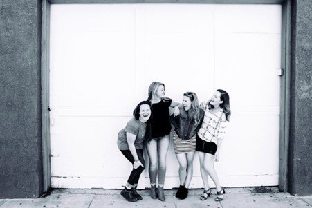 A photograph of four women smiling and having fun.