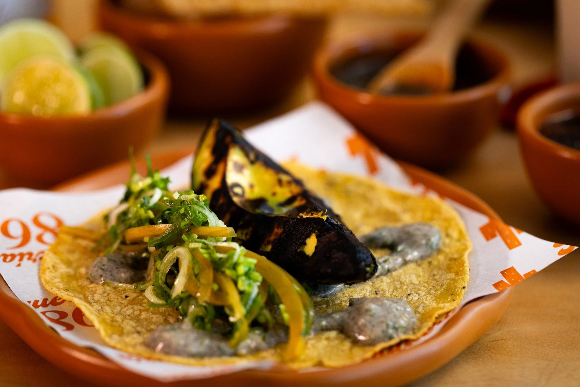 Taco de aguacate asado al carbón con ensalada de cilantro y chile amarillo