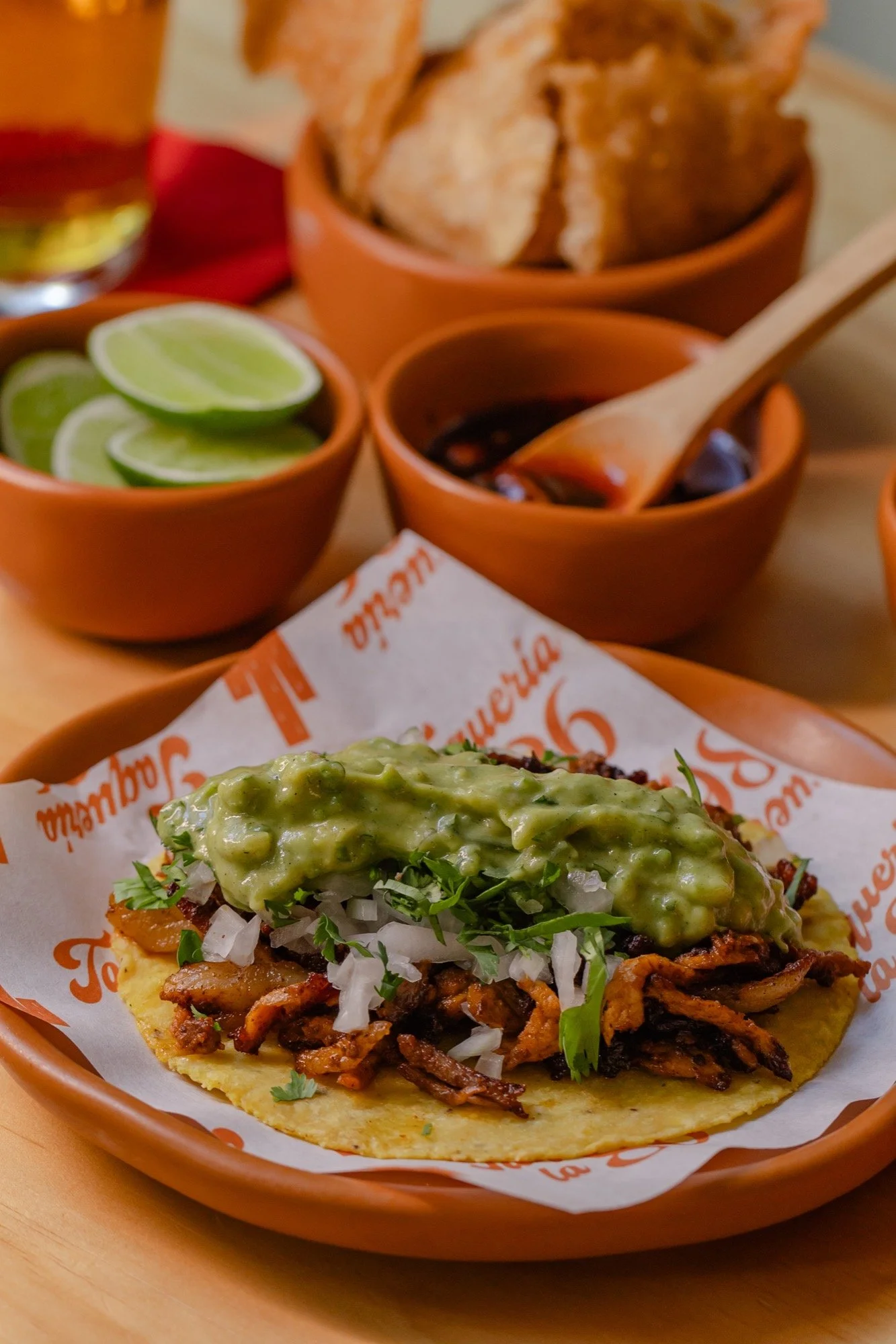 Taco al pastor con guacamole, cebolla y cilantro en tortilla de maíz