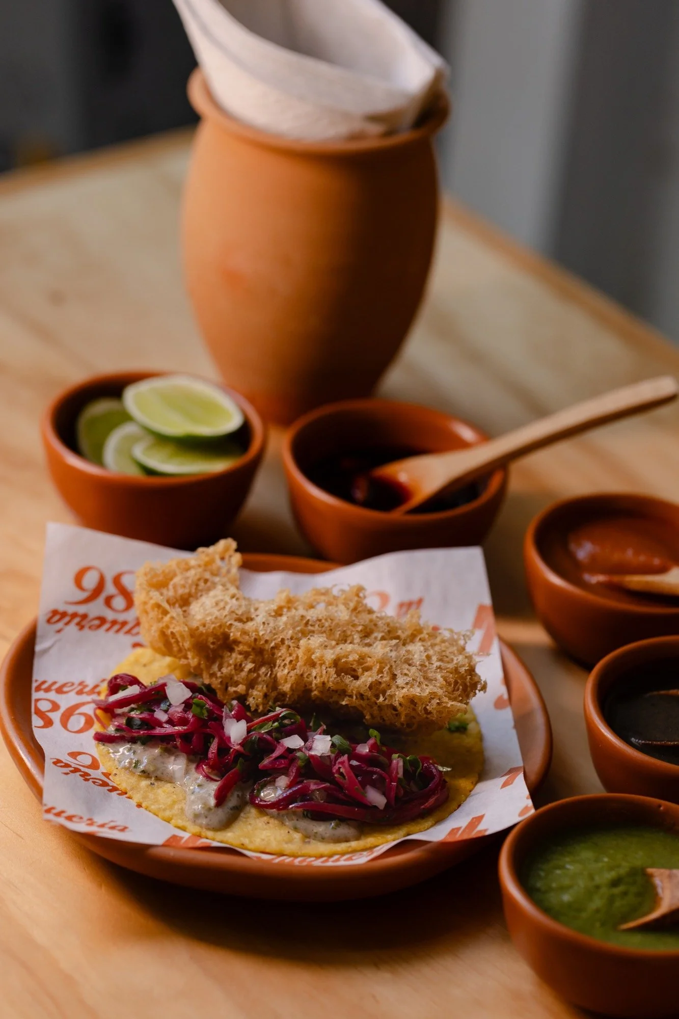 Taco de pescado en tempura con col morada y crujiente de tempura encima