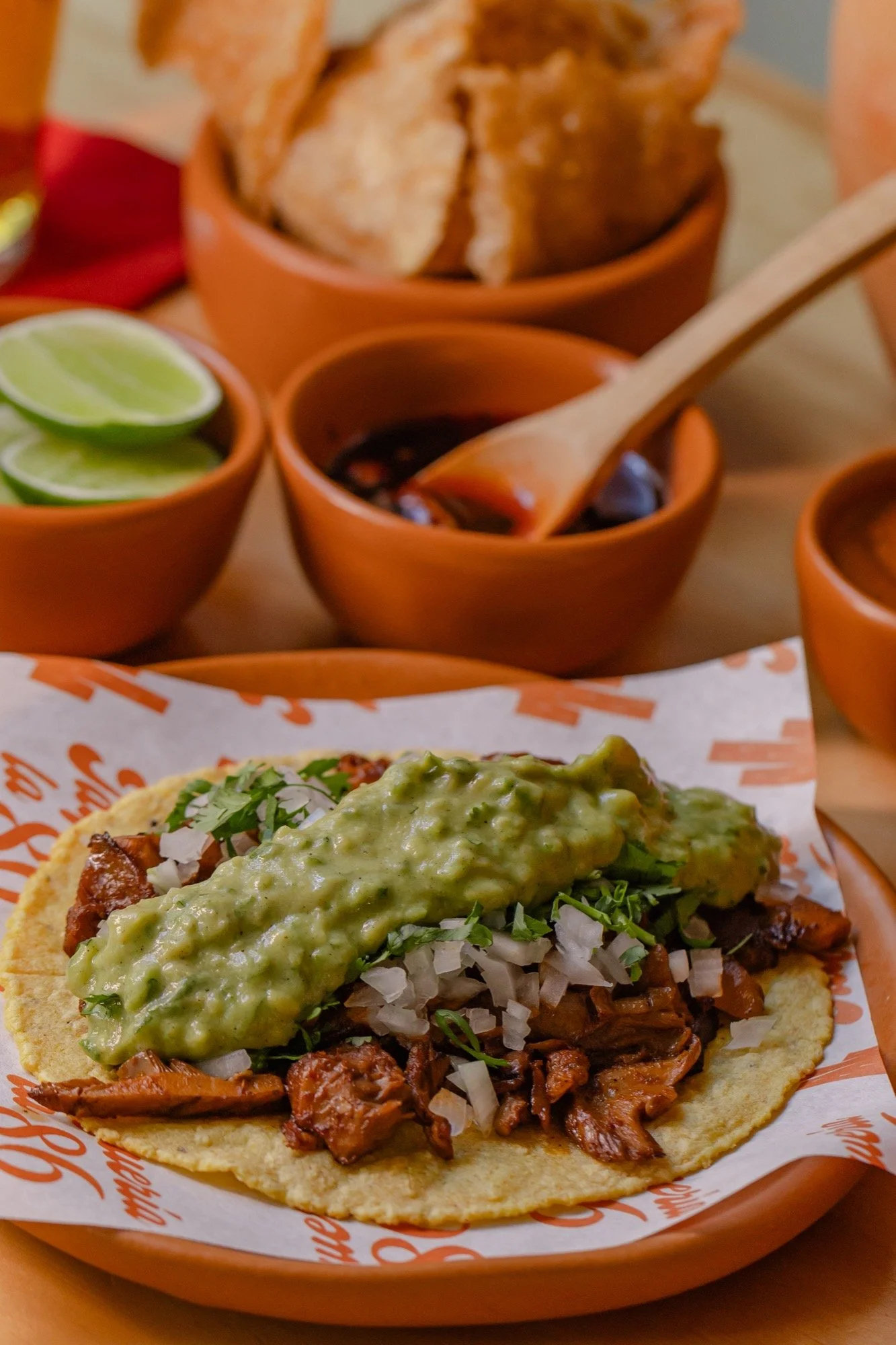 Taco de champiñones al carbón con guacamole, cebolla y cilantro
