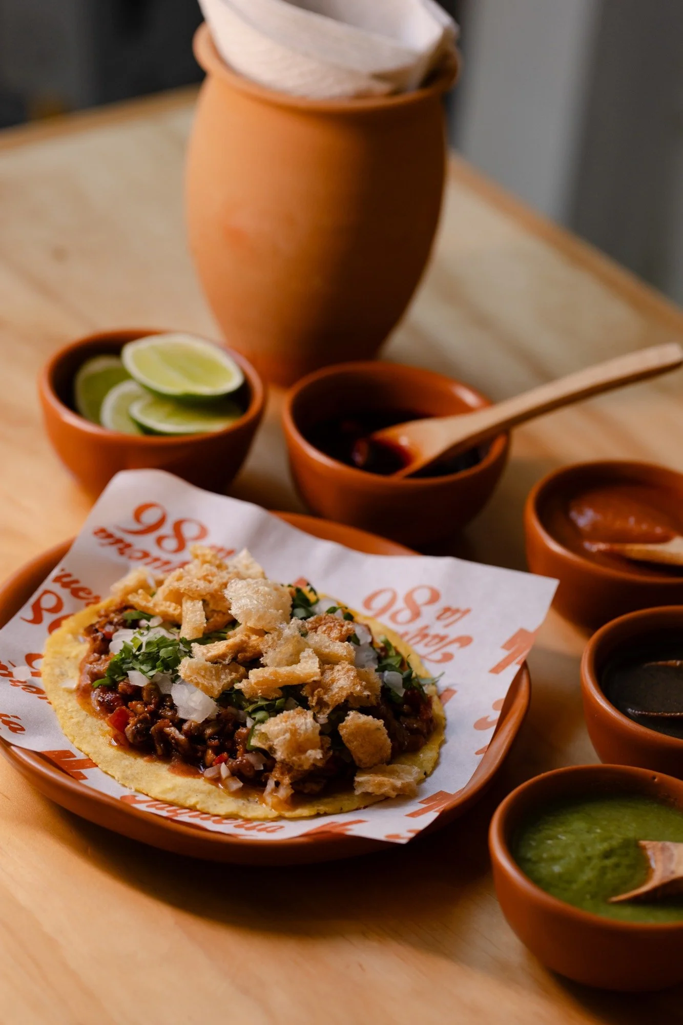 Taco campechano coronado con trozos de chicharrón, cebolla y cilantro