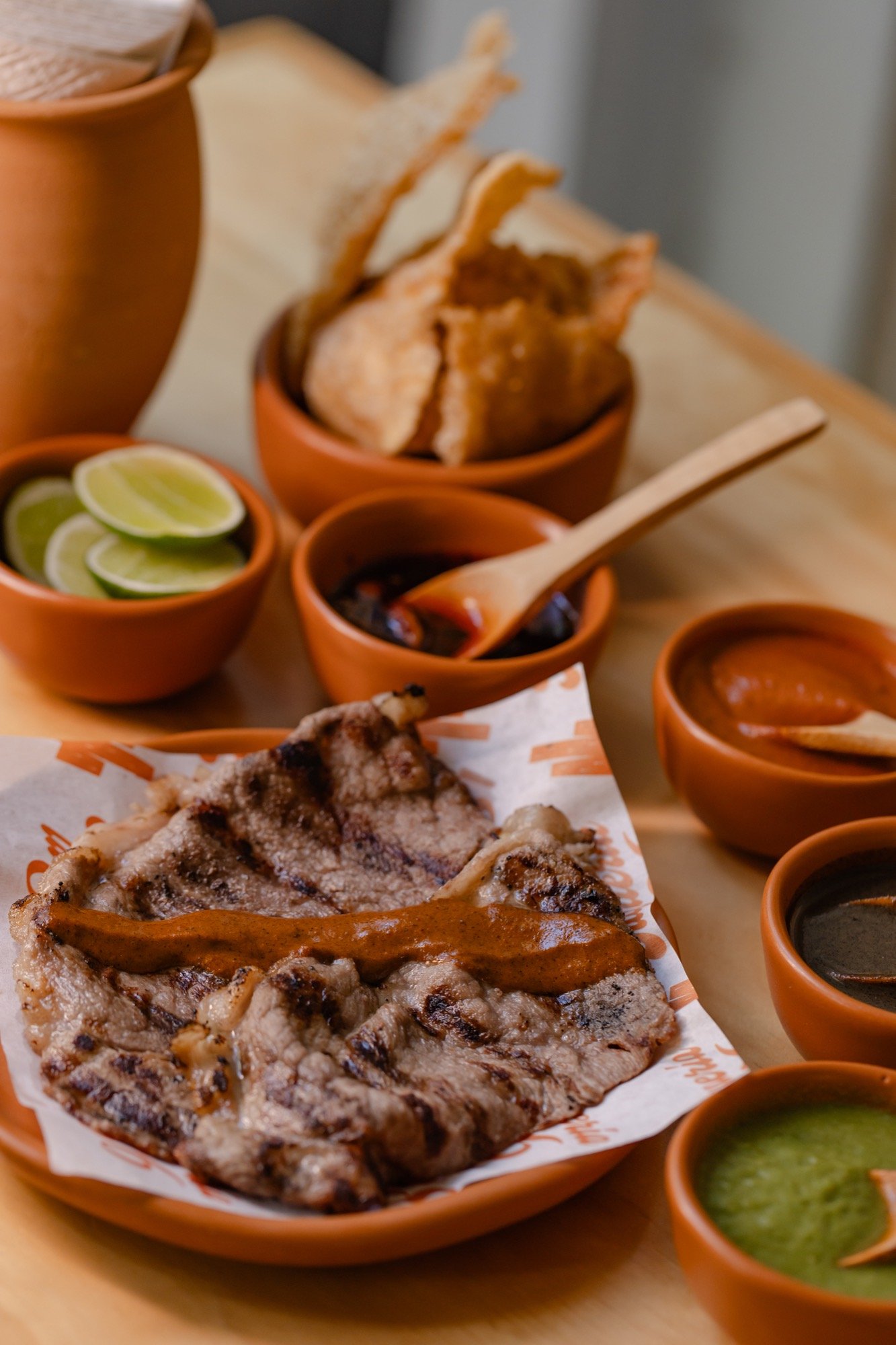 Taco Ribeye Prime a la parrilla con salsa encima, servido en plato de barro