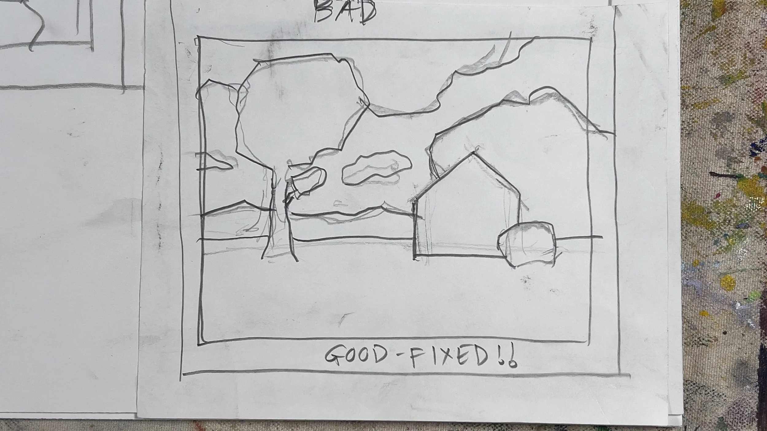 A hand-drawn sketch on paper showing a house, trees, and clouds, with the words 'BAD' written above and 'GOOD-FIXED!!' below.
