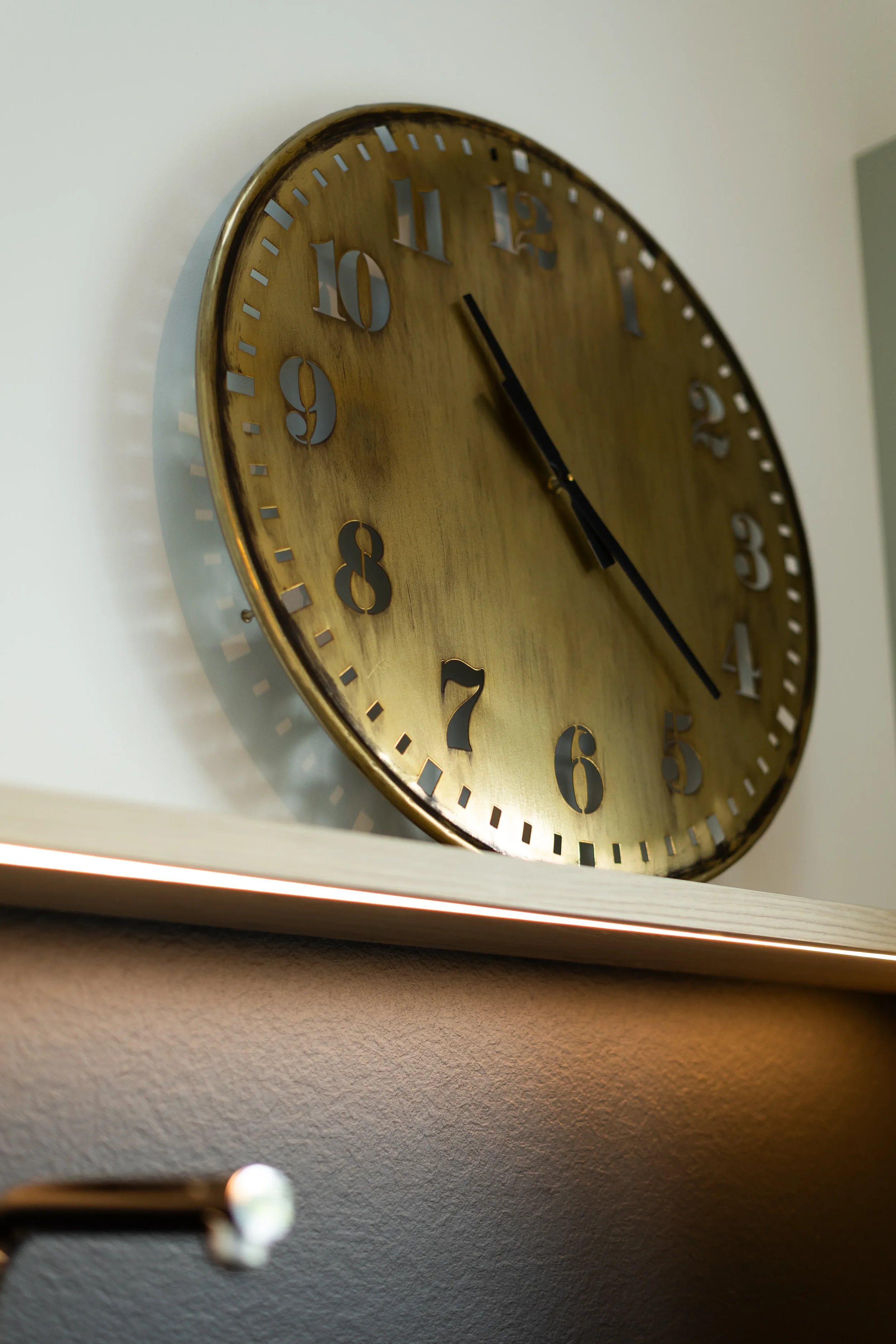 Horloge murale dorée avec chiffres romains, affichant 4h00.