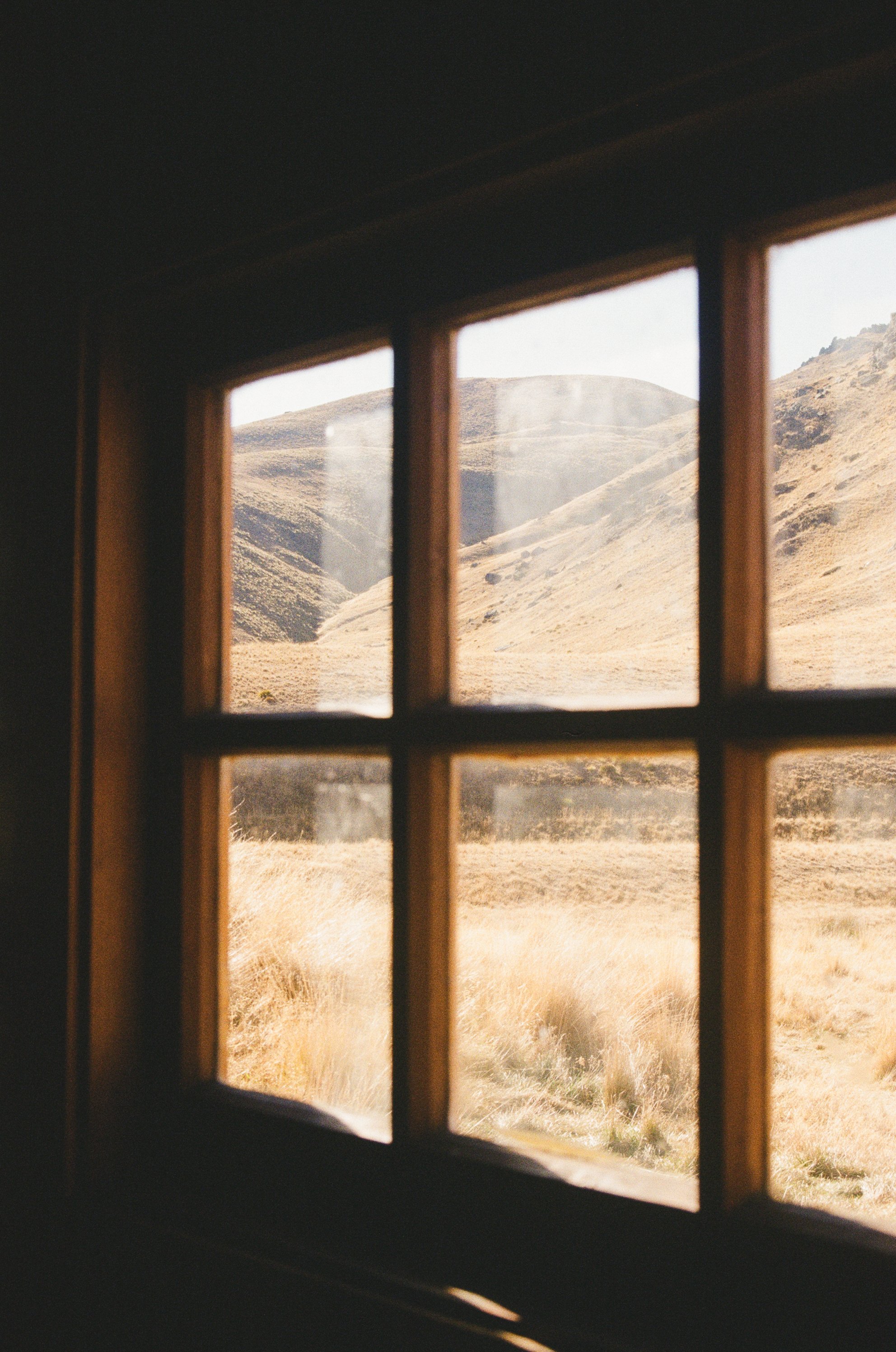 A moody window view of the mountains