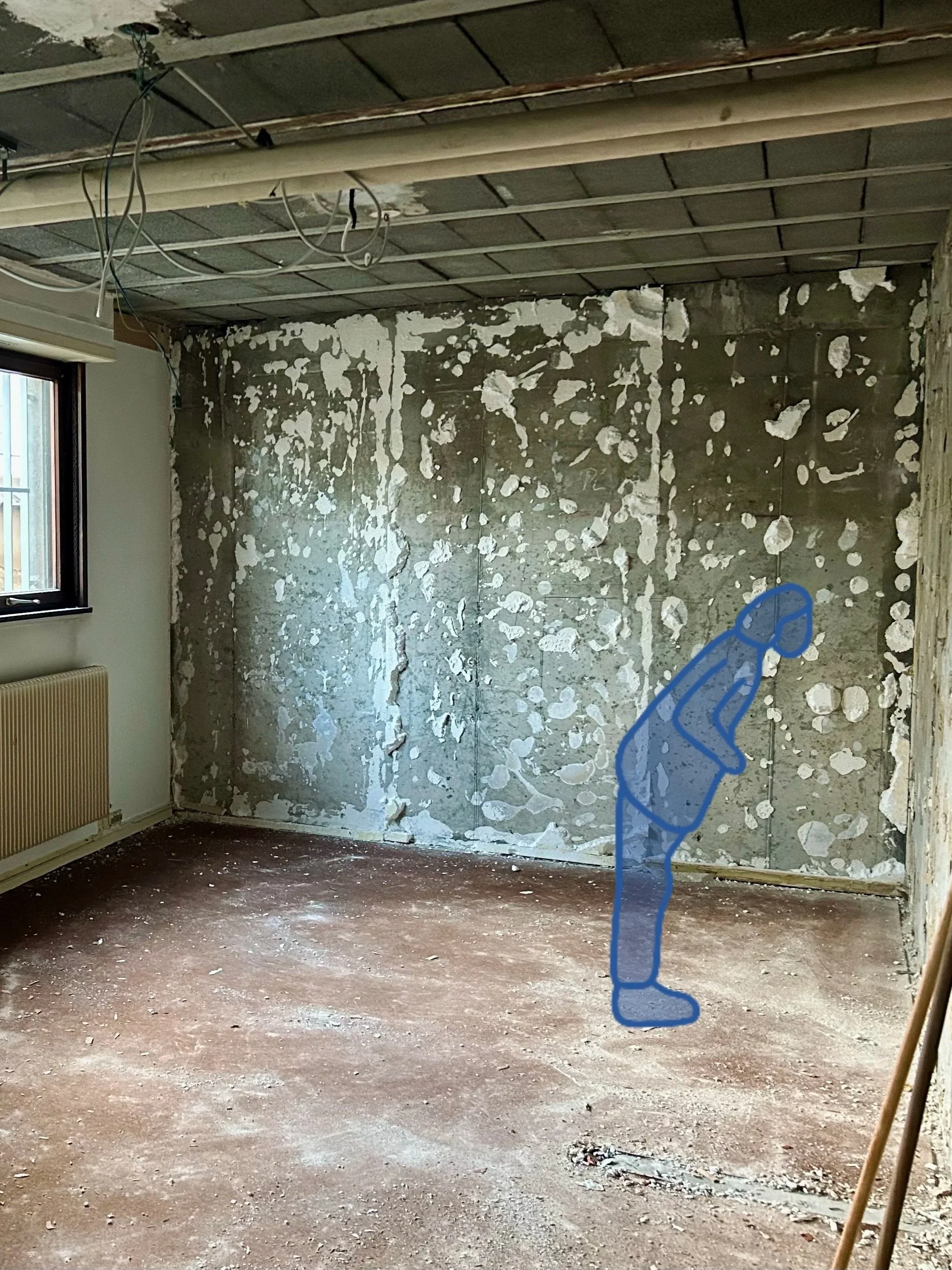 Une pièce en cours de rénovation avec un mur en train d'être rénové, une fenêtre à gauche, des câbles électriques suspendus au plafond en construction, un radiateur sous la fenêtre, et une silhouette dessinée à la main d'une personne dans la pièce.