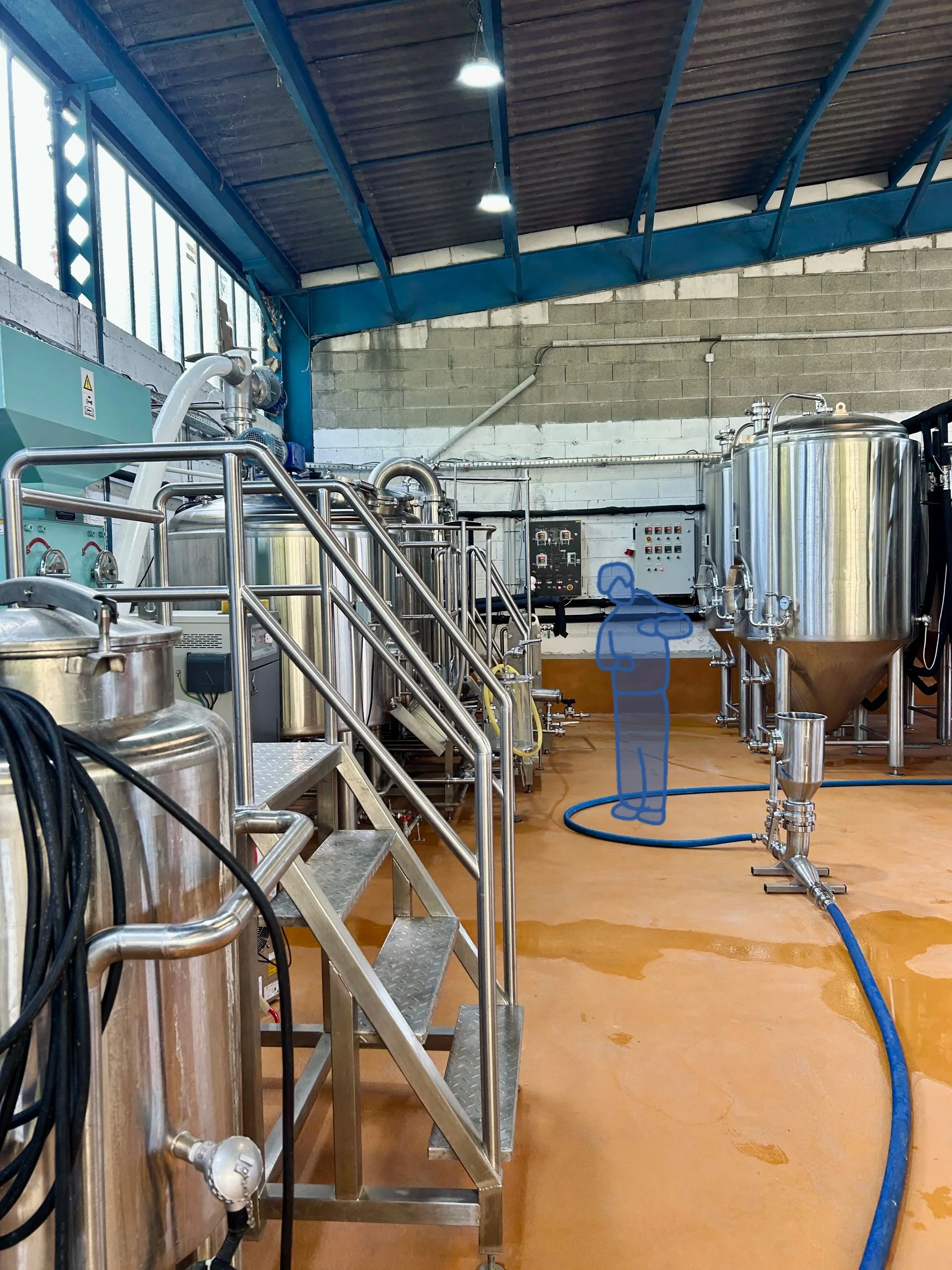 Intérieur d'une brasserie avec des équipements en métal, tuyaux, contrôleurs électriques, et une figure humaine en dessin en train d'observer ou d'inspecter l'installation et un sol en résine.
