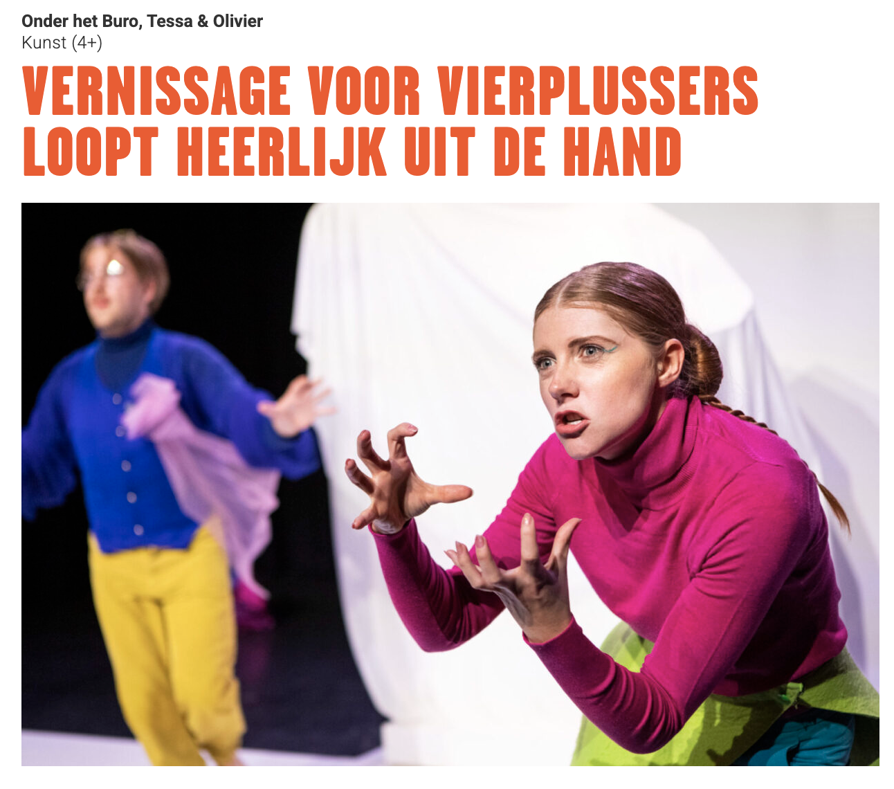 Twee acteurs tijdens een theaterworkshop, een vrouw in een roze trui die intensief acteert, en een man op de achtergrond in een blauw en geel kostuum.