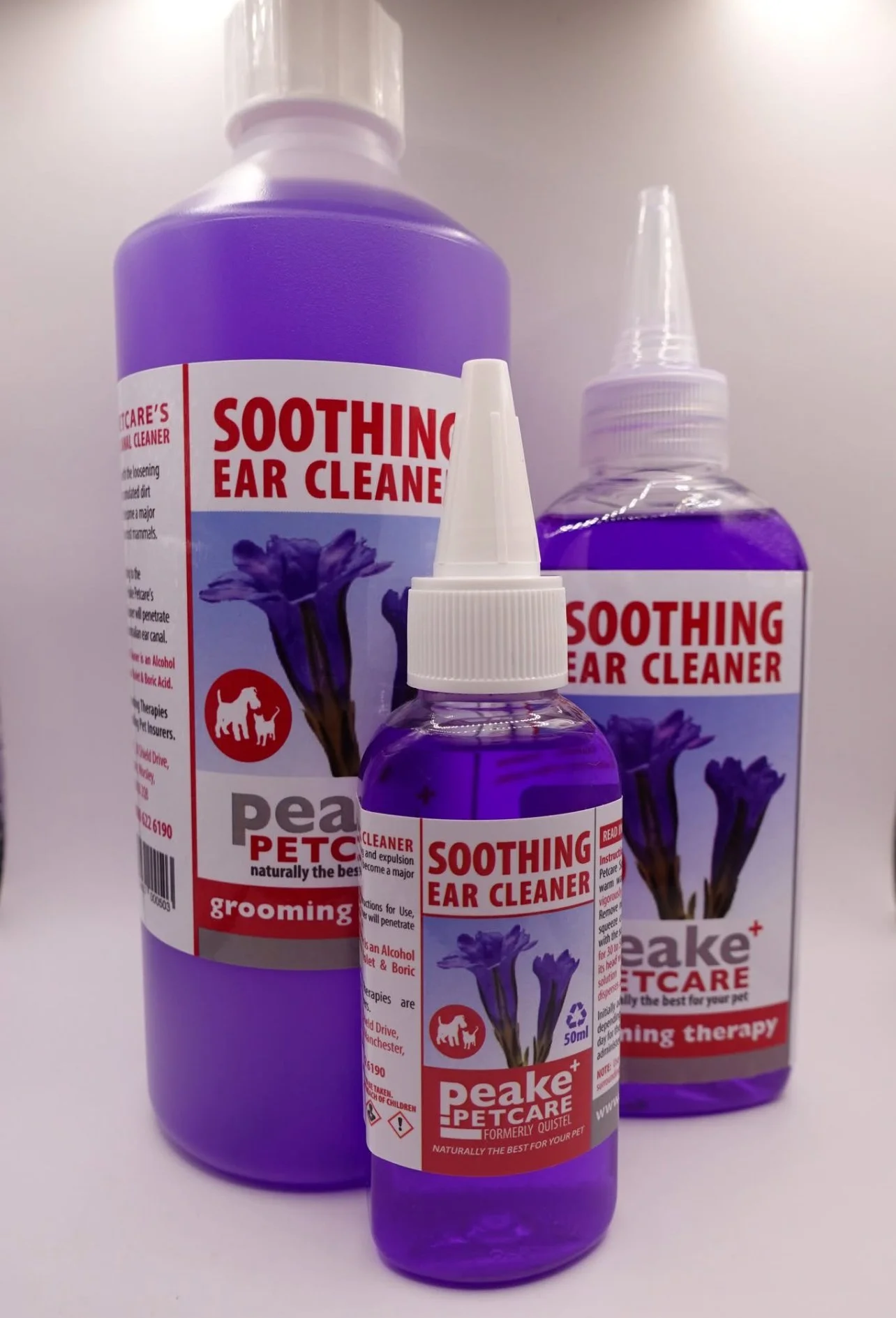 Three bottles of peake petcare soothing ear cleaner in purple liquid, with labels showing a purple flower and a red dog logo, placed on a white surface.