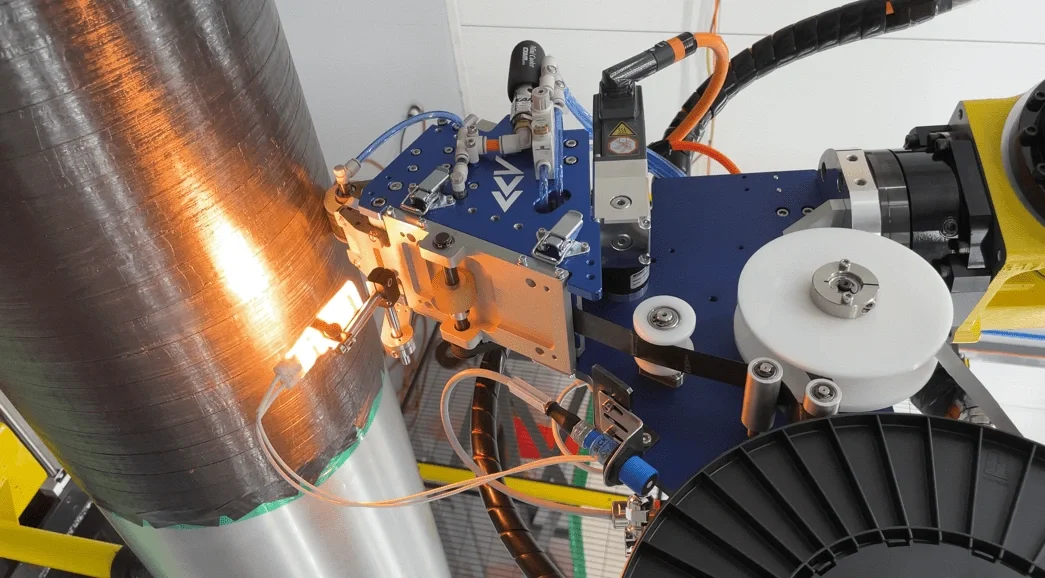 Close-up of scientific equipment with a large metallic cylinder connected to various sensors, wires, and mechanical parts, likely used in a scientific or engineering experiment.