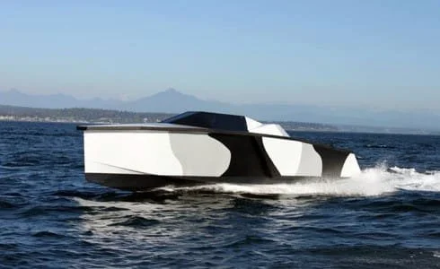 Modern motorboat speeding on the water with a mountain range in the background.