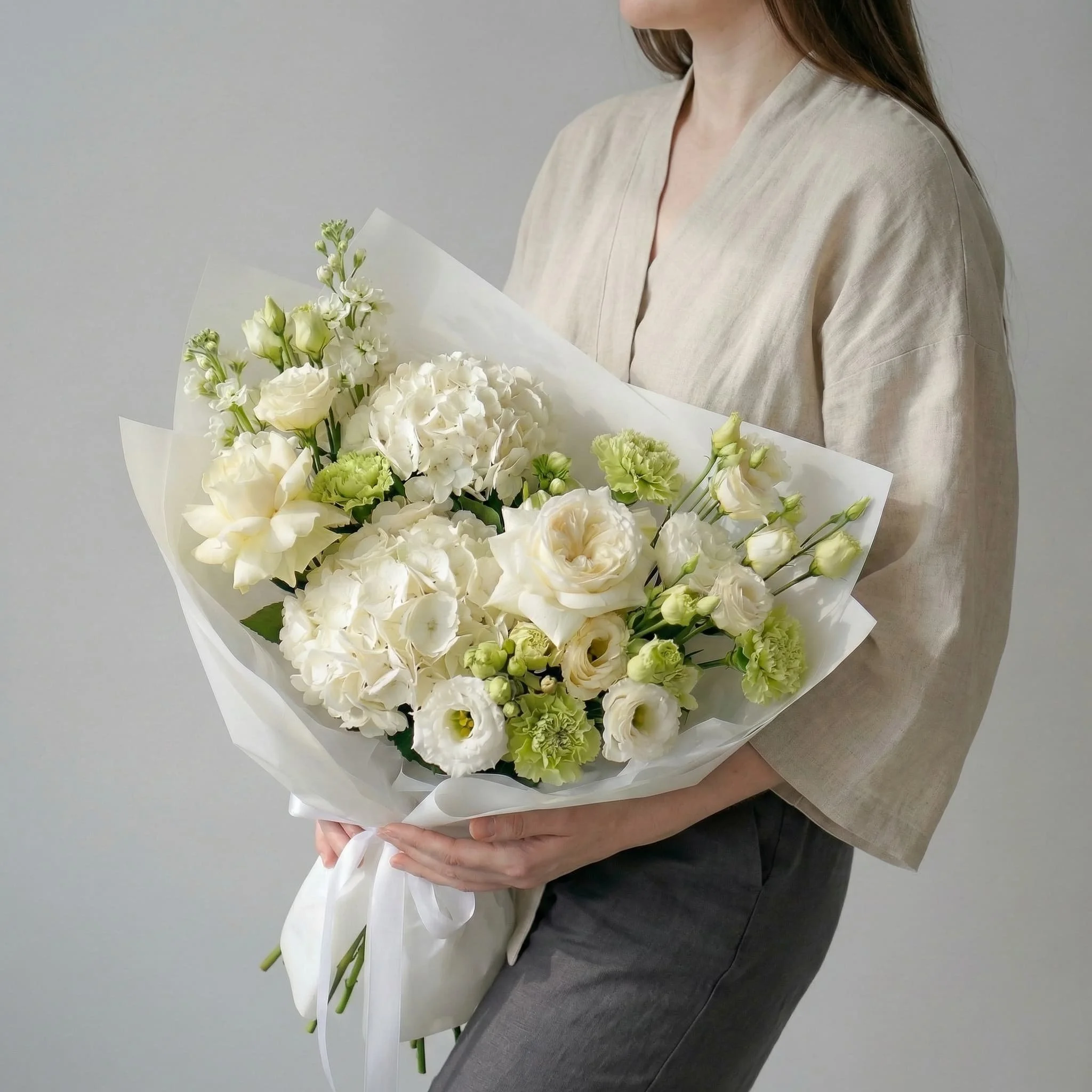 HORA Flowers seasonal white bouquet in white wrap, hand held in studio