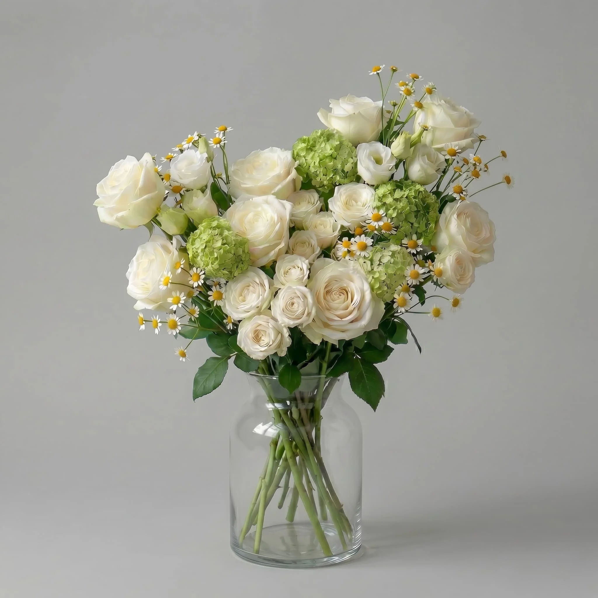 White rose bouquet with hydrangeas, chamomile-style daisies, and fresh greenery arranged in a clear glass vase by HORA Flowers Perth.