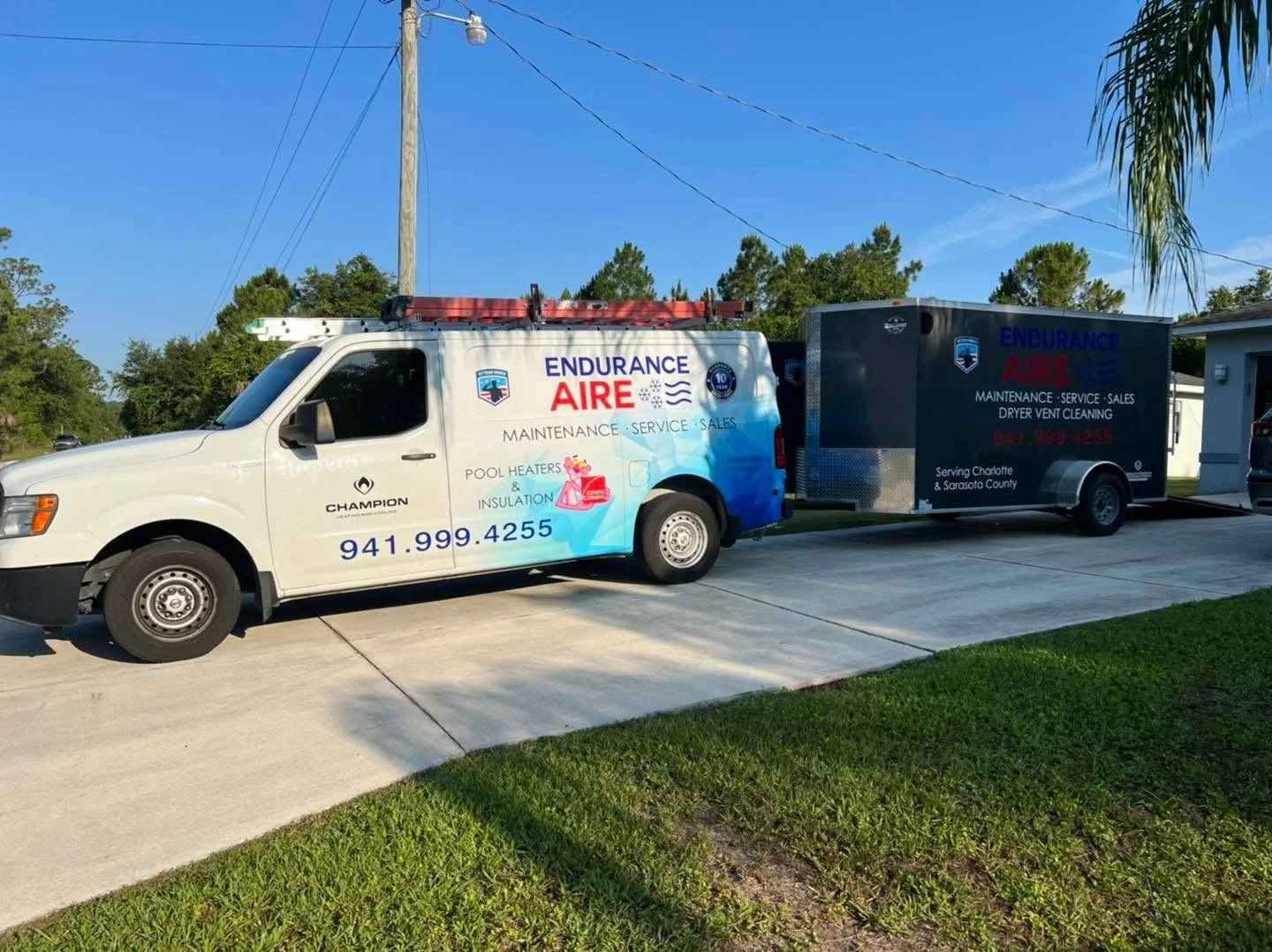 Service vehicle with advertising for pool heater and insulation maintenance, with a trailer attached, parked on a driveway under a blue sky with trees and utility pole in the background.