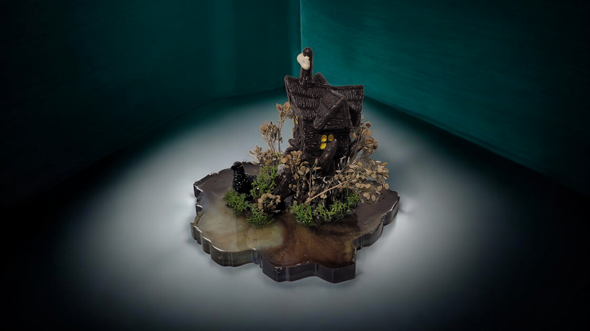 The Shadowwood Sanctum
“Not all who wander the dark are lost; some are just coming home.”
The Shadowwood Sanctum is a 1-of-1 original relic, featuring a hand-sculpted woodland cottage perched upon a deep, swirling resin abyss. Adorned with preserved 