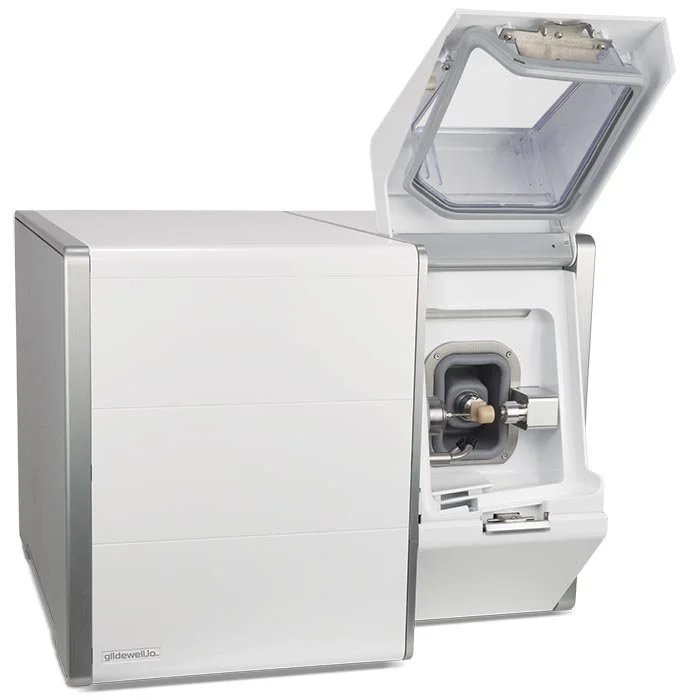 A laboratory instrument with a closed section on the left and an open section on the right, featuring a prism and mechanical parts, used for scientific analysis or research.