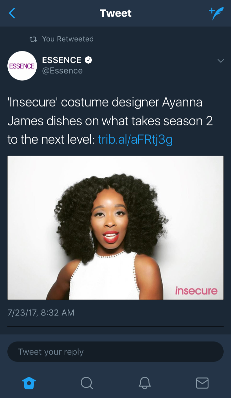 A woman with curly black hair wearing a white sleeveless top with beads around the neckline, red lipstick, and large earrings, standing against a plain white background.