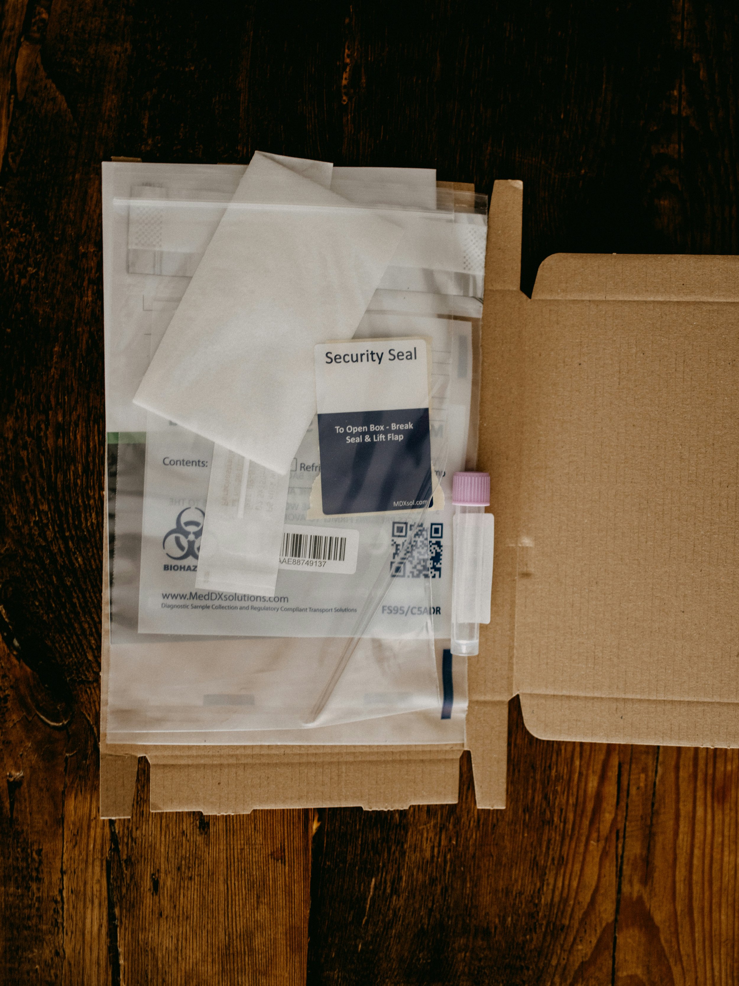 Medical testing kit packaged in box with security seal and instructions.