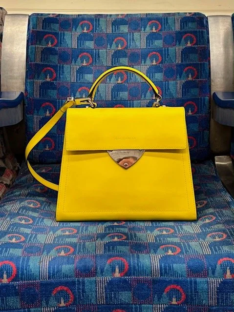 A yellow bag on a train seat
