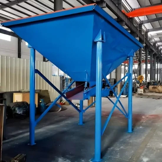 Large blue industrial hopper or silo with a conical shape in a warehouse or factory setting.